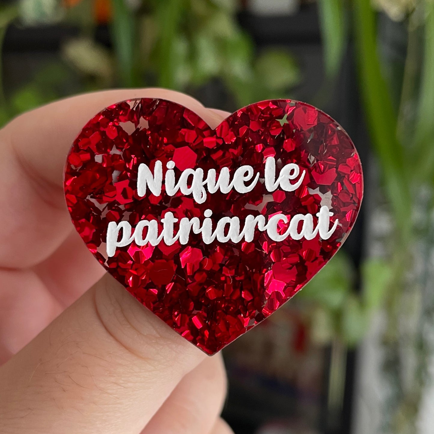 Broche "Nique le patriarcat" en acrylique semi-transparente avec des confettis rouges