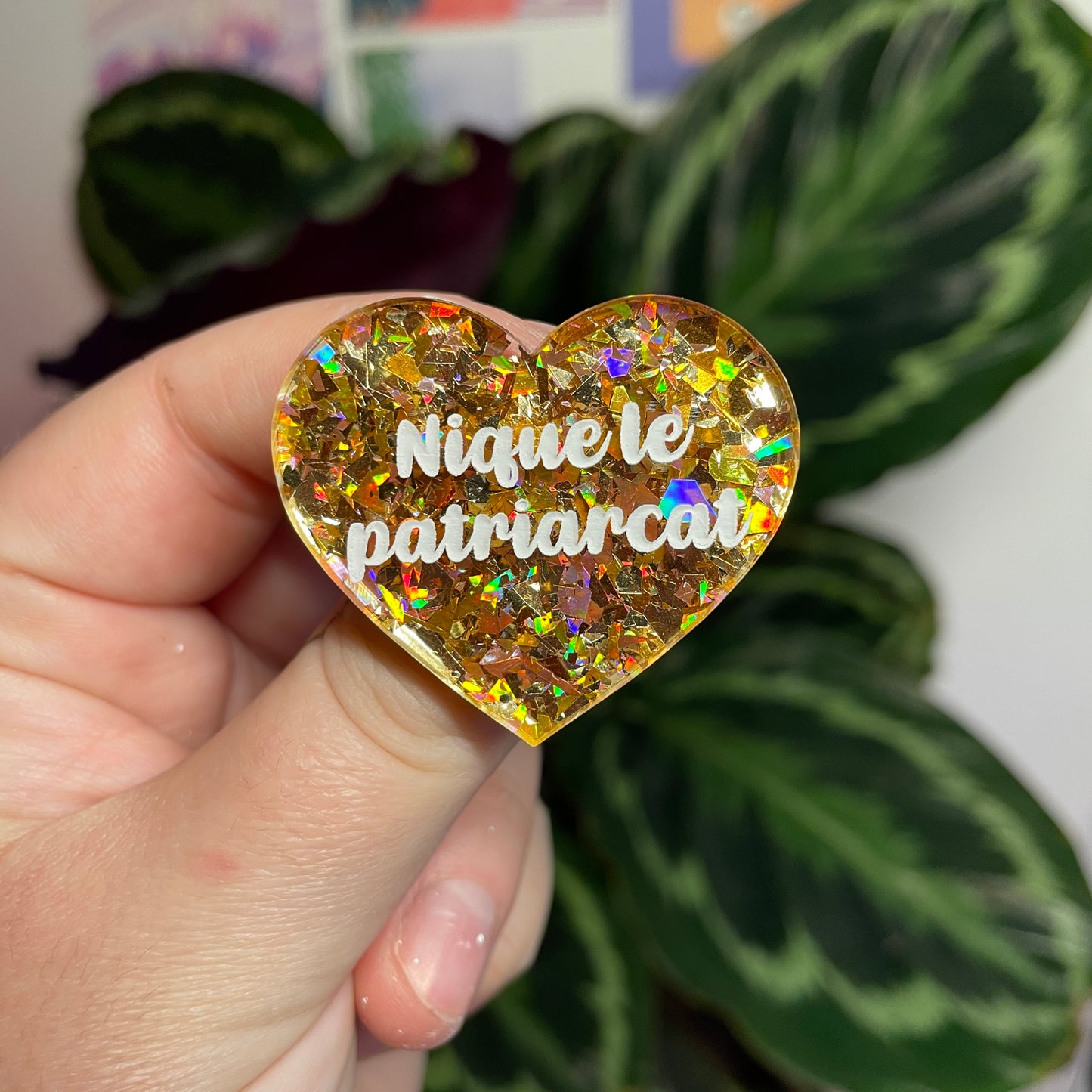 Broche "Nique le patriarcat" en acrylique transparente avec des éclats de confettis jaunes