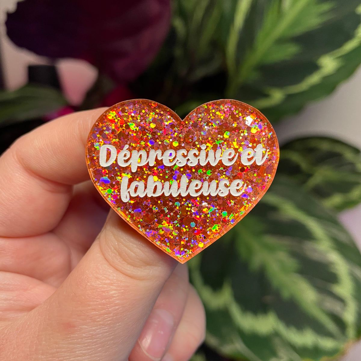 Broche "Dépressive et fabuleuse" en acrylique semi transparente avec des paillettes corail