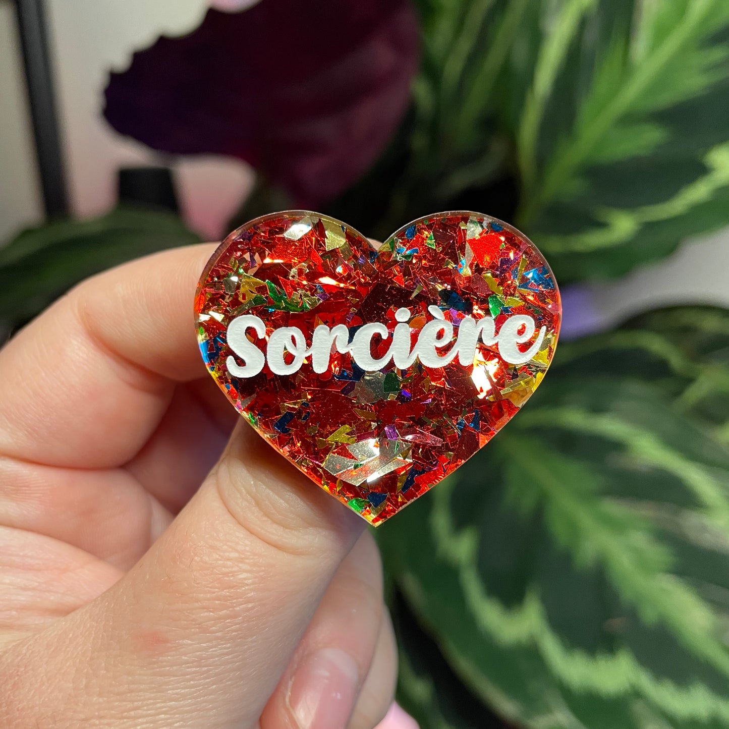 Broche "Sorcière" en acrylique transparente avec des paillettes rouges et multicolores