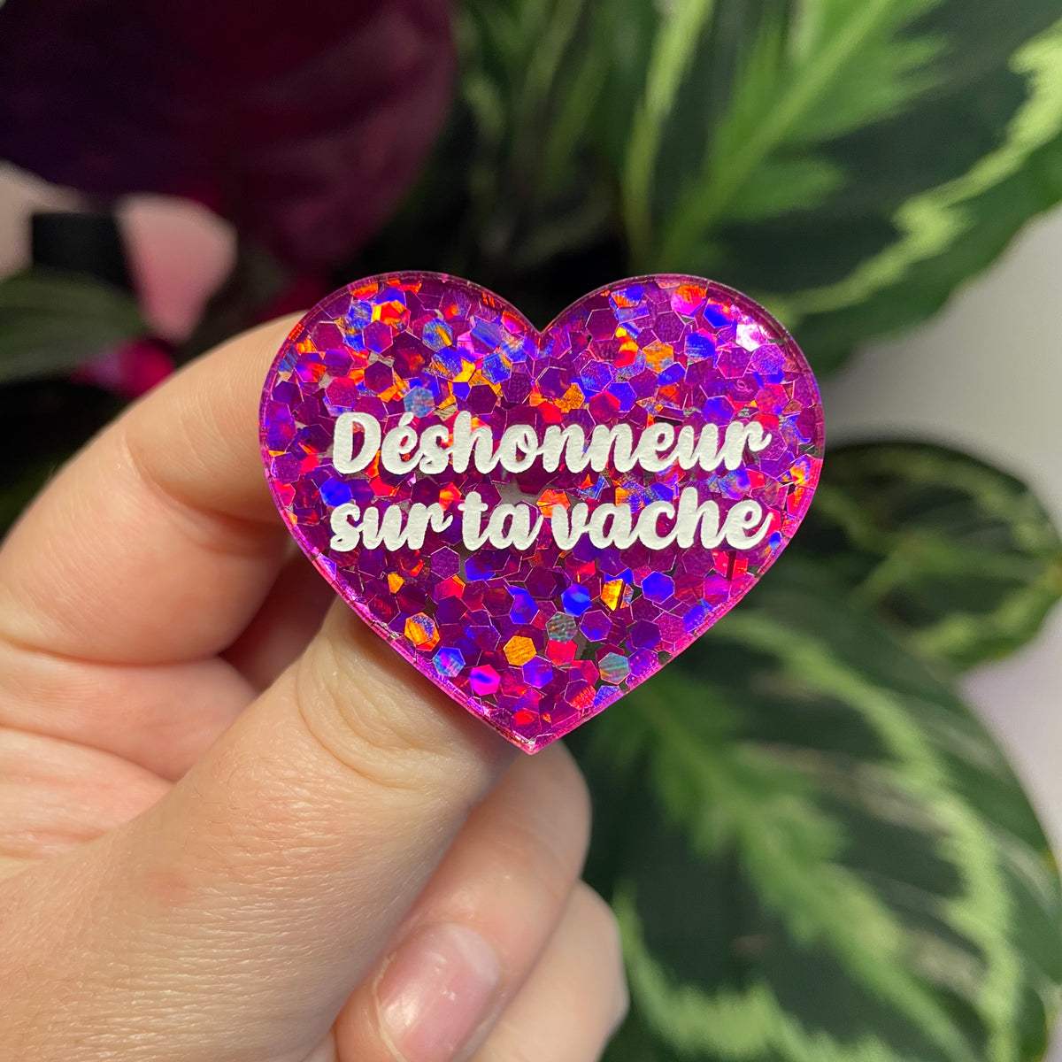 Broche "Déshonneur sur ta vache" en acrylique semi transparente avec des confettis fuchsia
