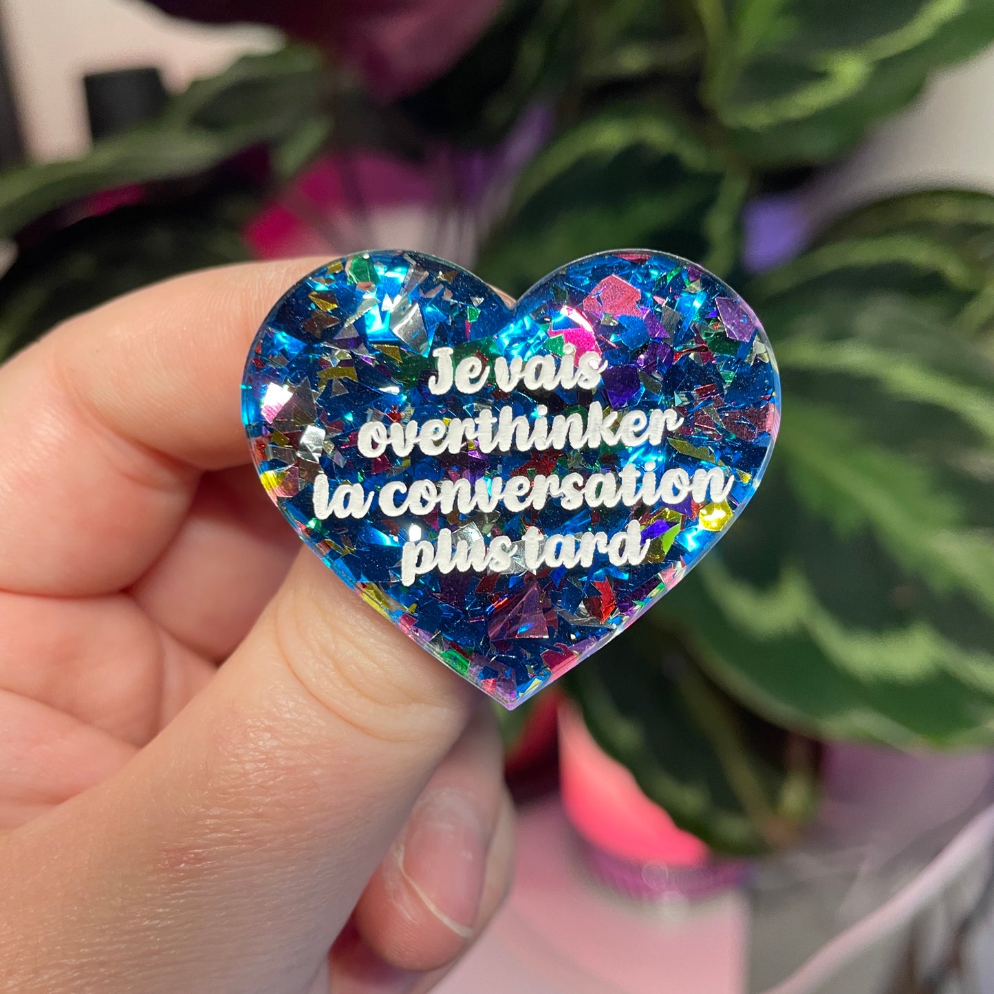 Broche "Je vais overthinker la conversation plus tard" en acrylique transparente avec des confettis bleus et multicolores