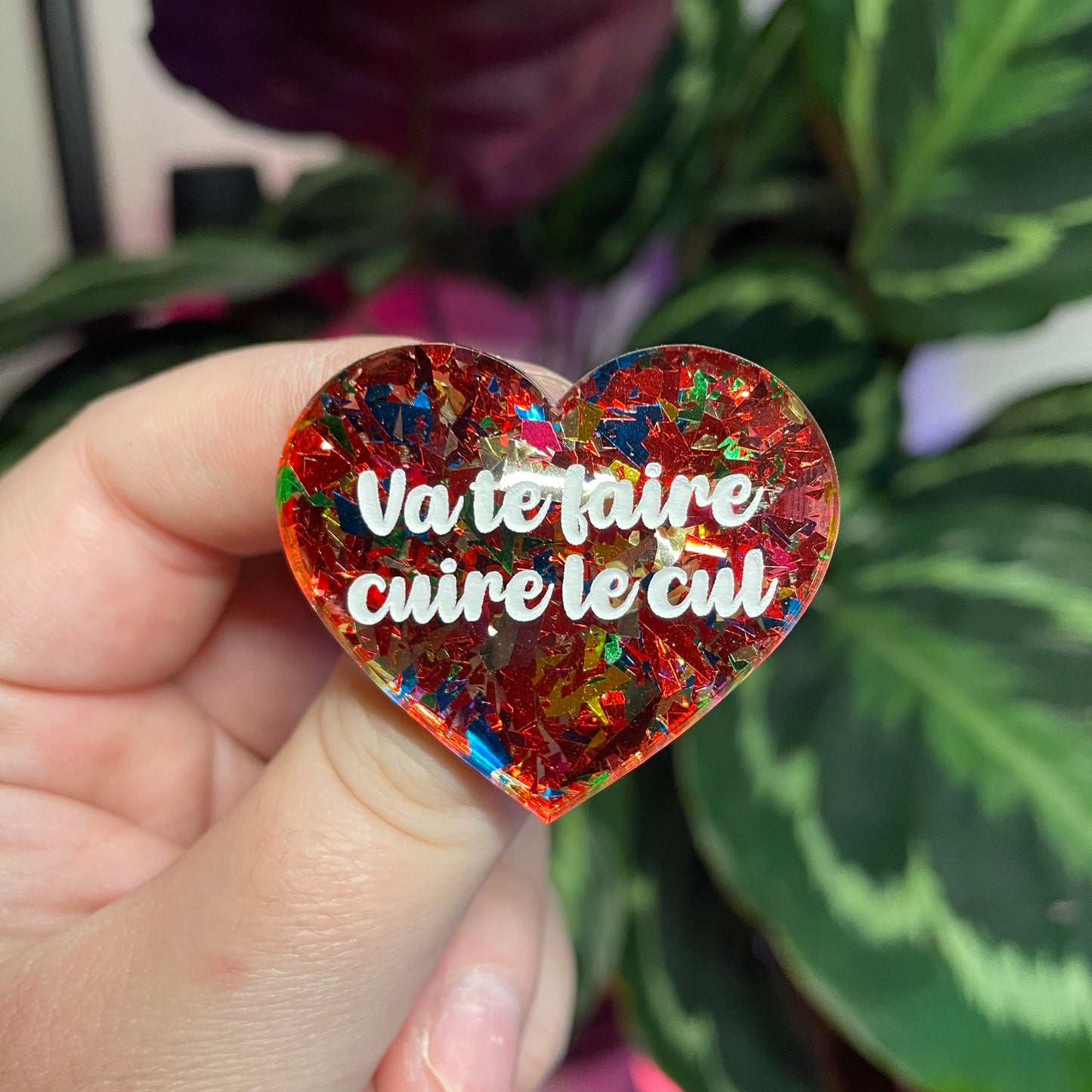 Broche "Va te faire cuire le cul" en acrylique transparente avec des confettis rouges et multicolores