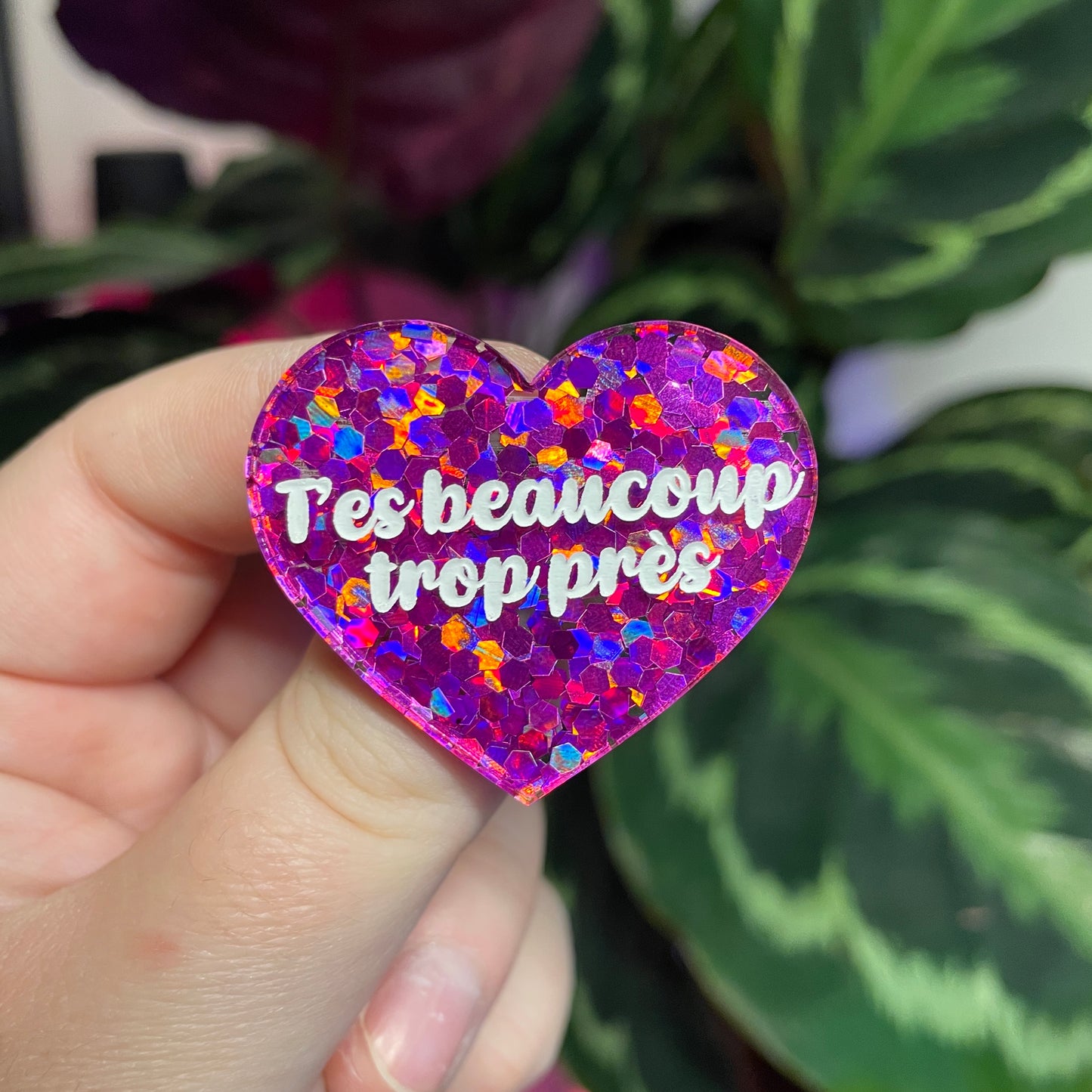Broche "T'es beaucoup trop près" en acrylique semi transparente avec des confettis fuchsia