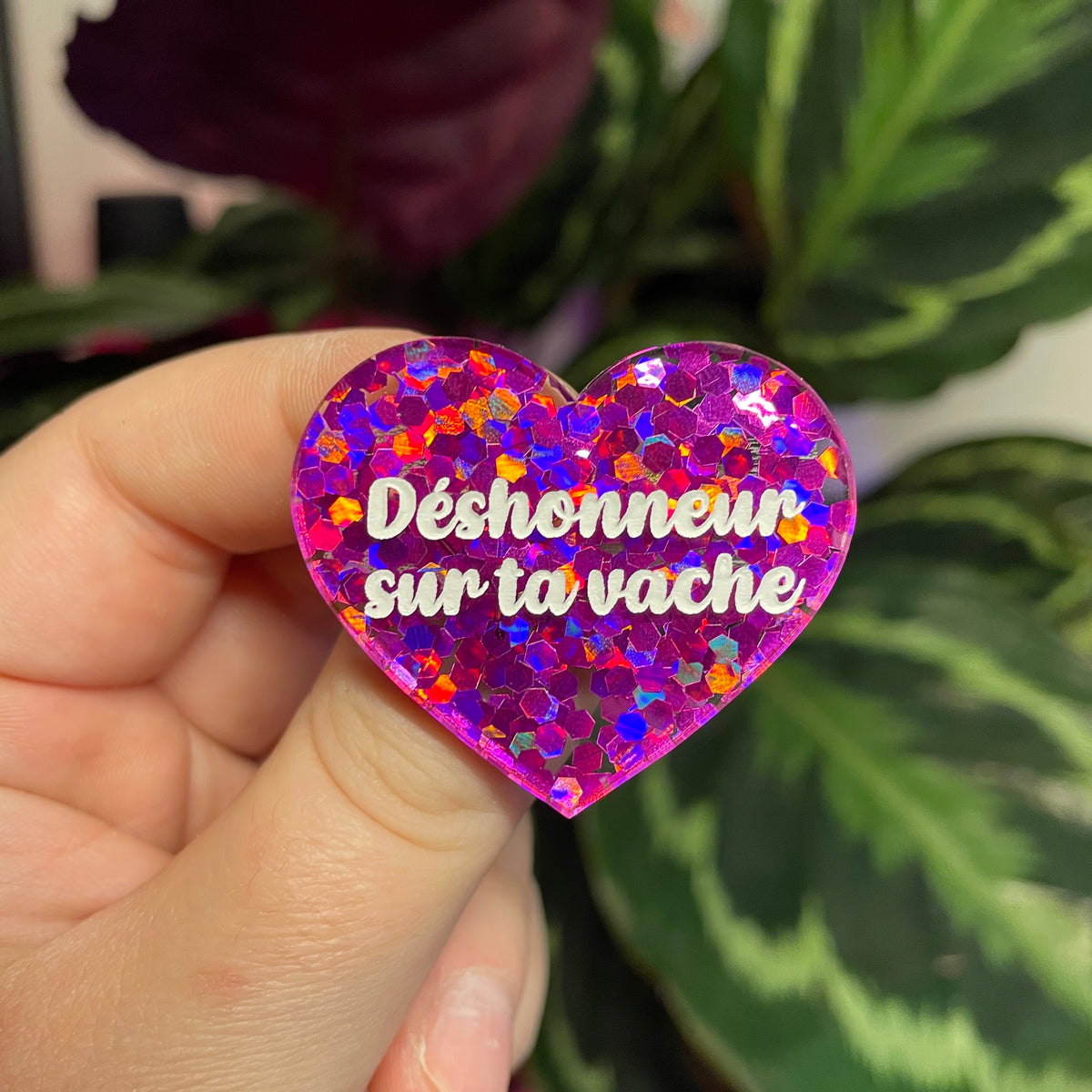 Broche "Déshonneur sur ta vache" en acrylique semi transparente avec des confettis fuchsia