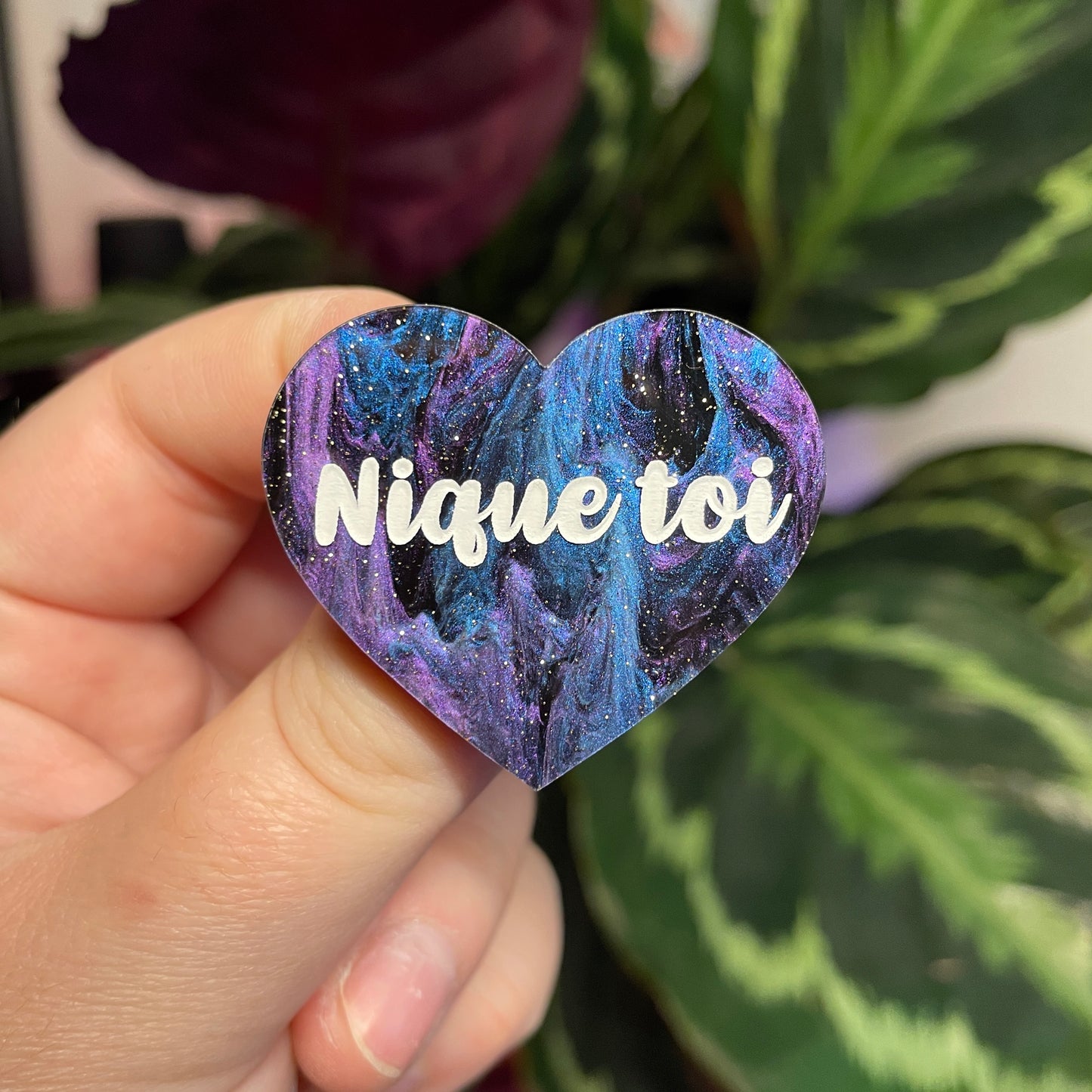 Broche "Nique toi" en acrylique marbrée bleue, noire et violette à paillettes