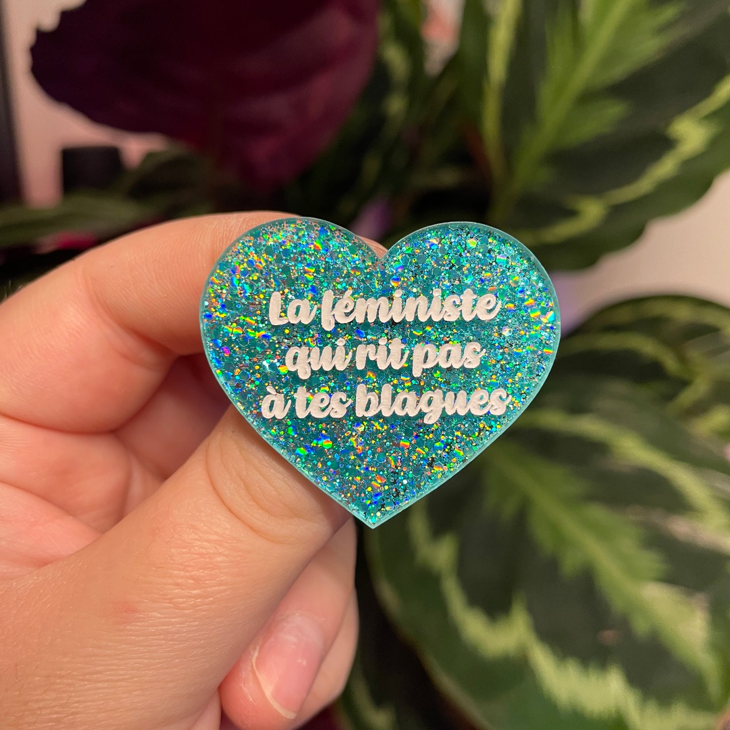 Broche "La féministe qui rit pas à tes blagues" en acrylique à paillettes turquoise
