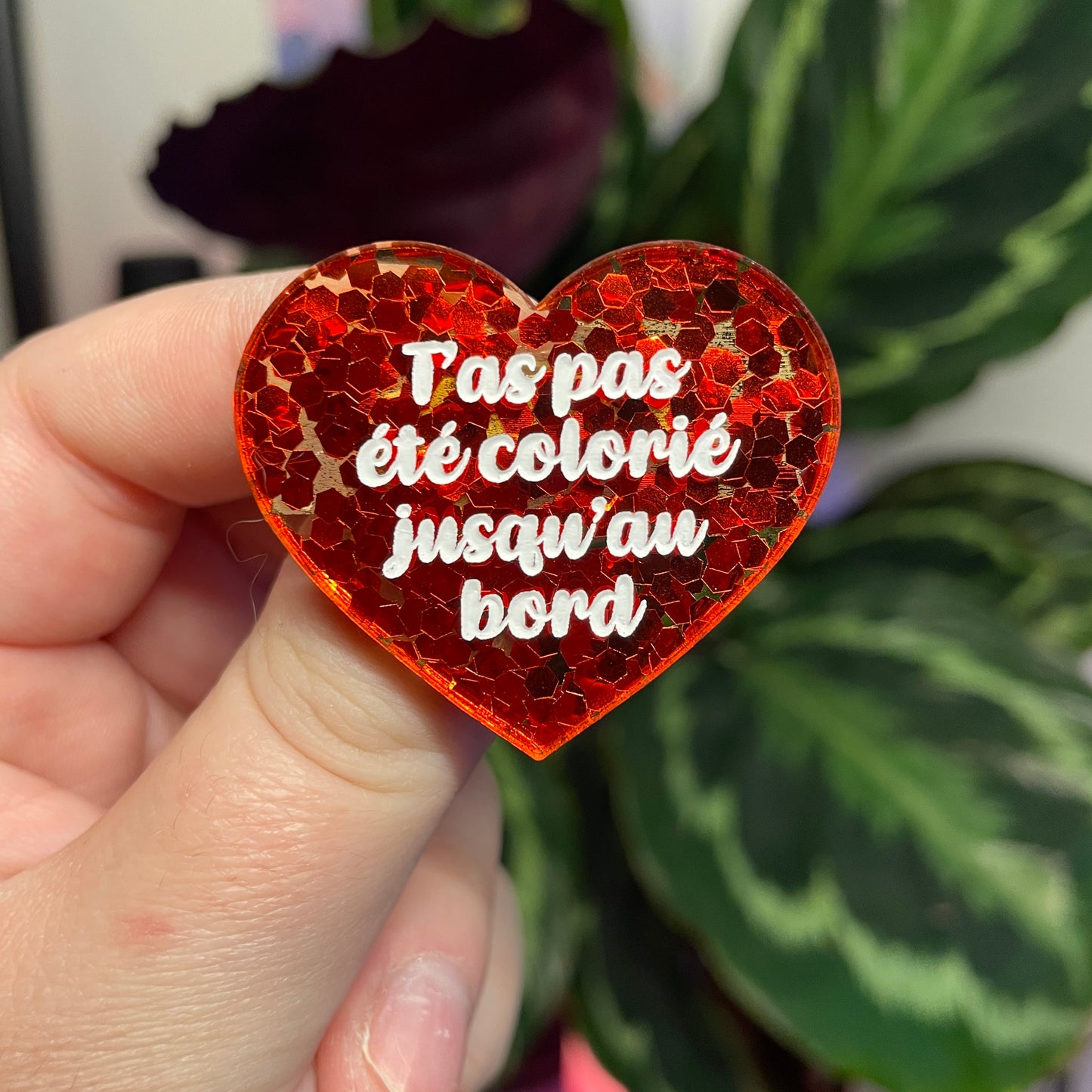 Broche "T'as pas été colorié jusqu'au bord" en acrylique semi transparente avec des confettis rouges