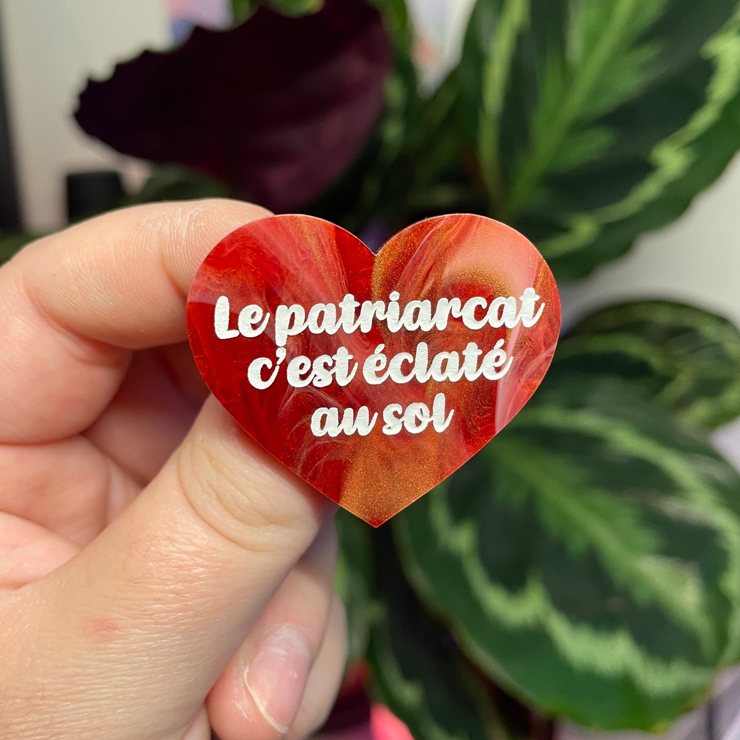 Broche "Le patriarcat c'est éclaté au sol" en acrylique marbrée rouge, blanche et dorée