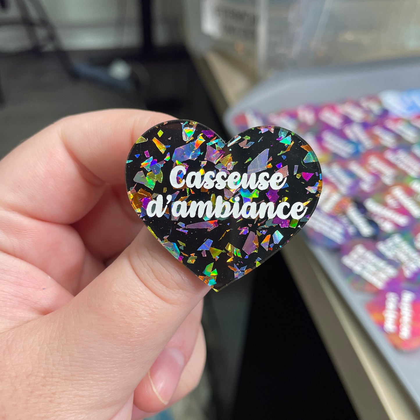 Broche "Casseuse d'ambiance" en acrylique noire avec des éclats de confettis multicolores