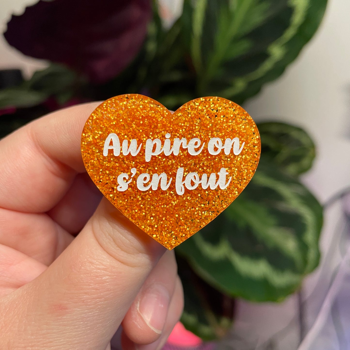 Broche "Au pire on s'en fout" en acrylique orange à paillettes
