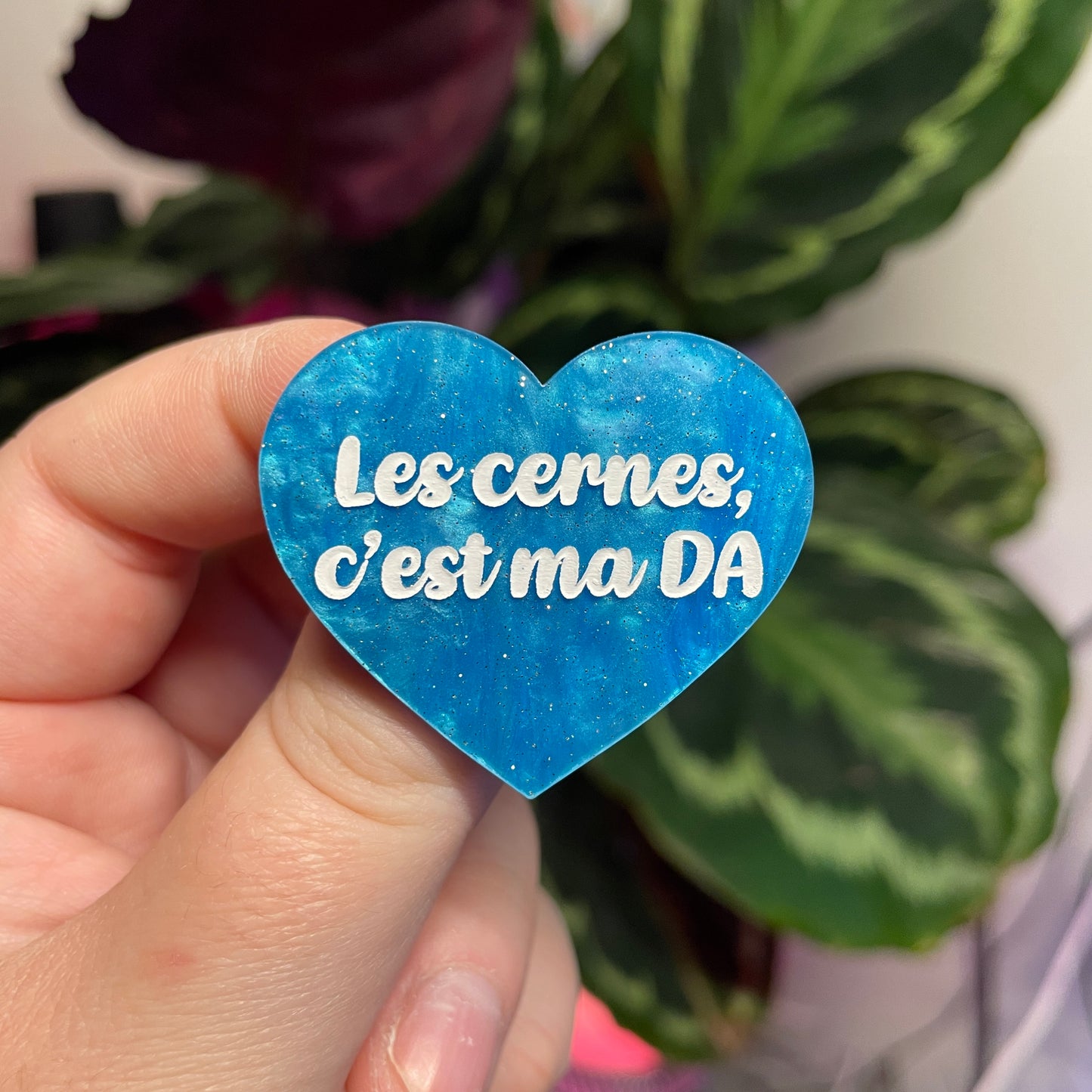 Broche "Les cernes c'est ma DA" en acrylique marbrée bleue à paillettes