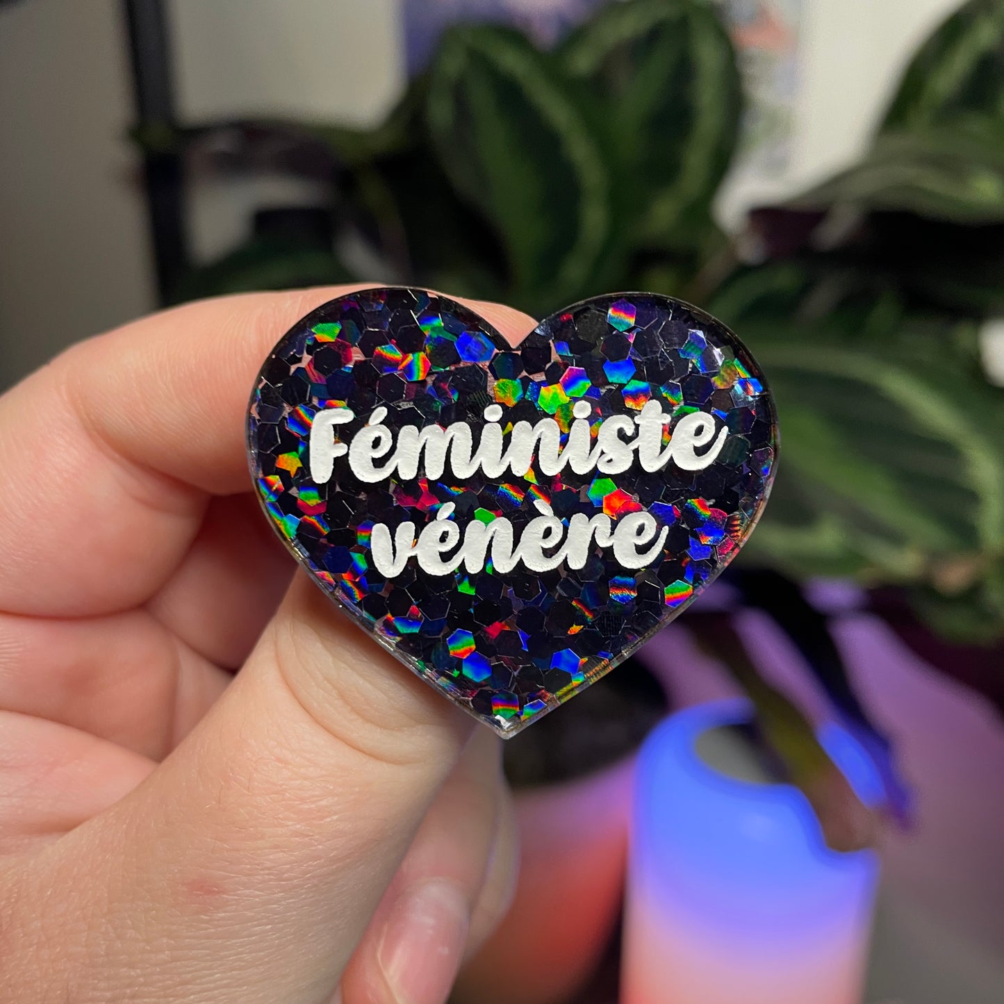 Broche "Féministe vénère" en acrylique semi transparente avec des confettis noirs