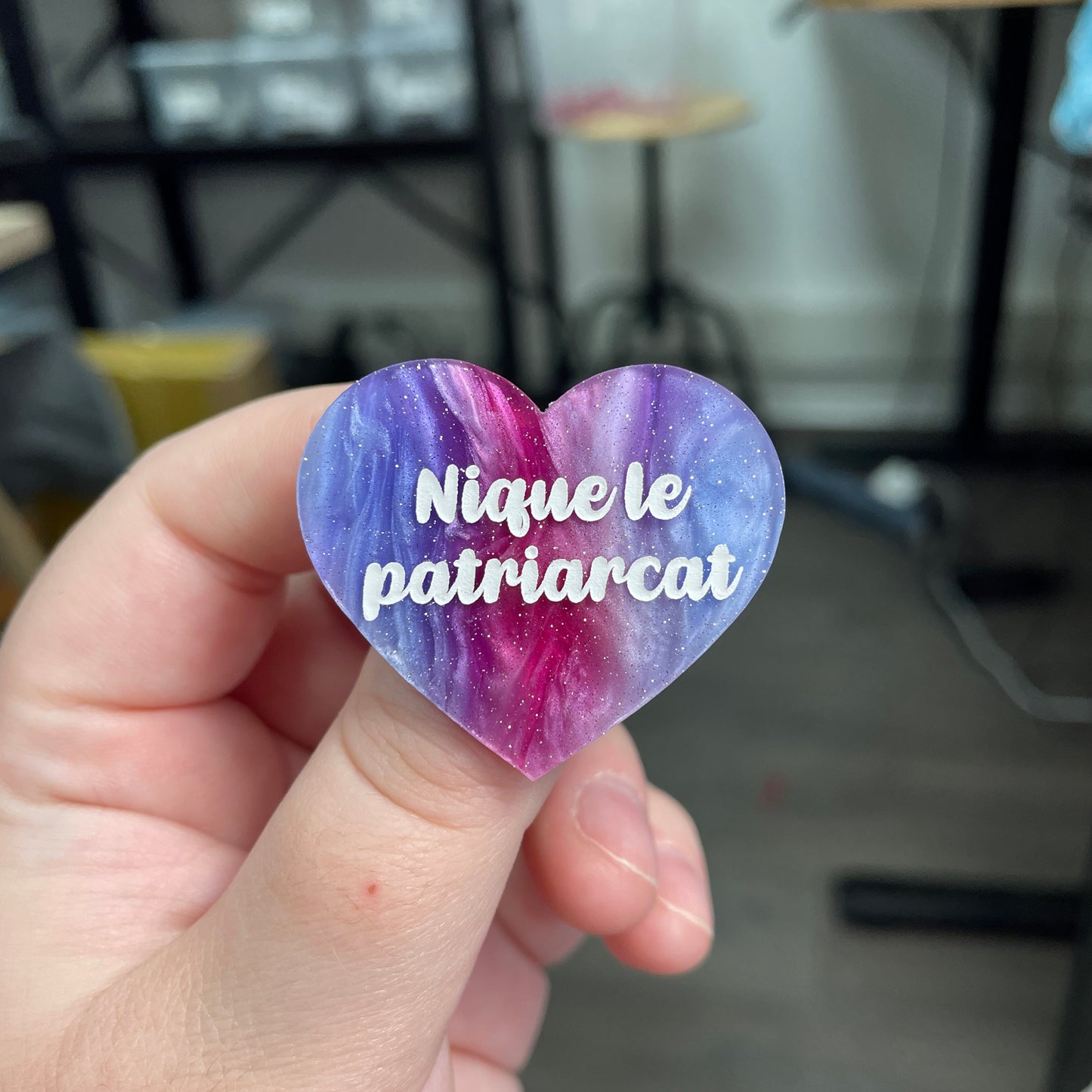 Broche "Nique le patriarcat" en acrylique marbrée bleue, rose et blanche à paillettes