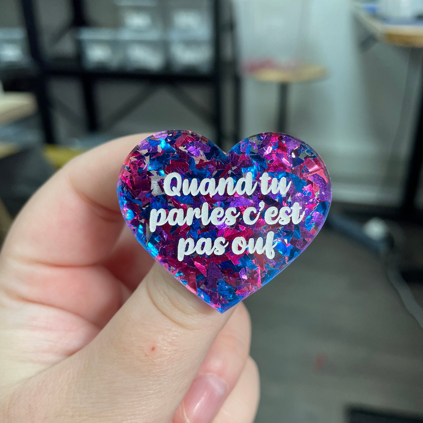 Broche "Quand tu parles c'est pas ouf" en acrylique transparente à gros confettis bleus et violets/roses