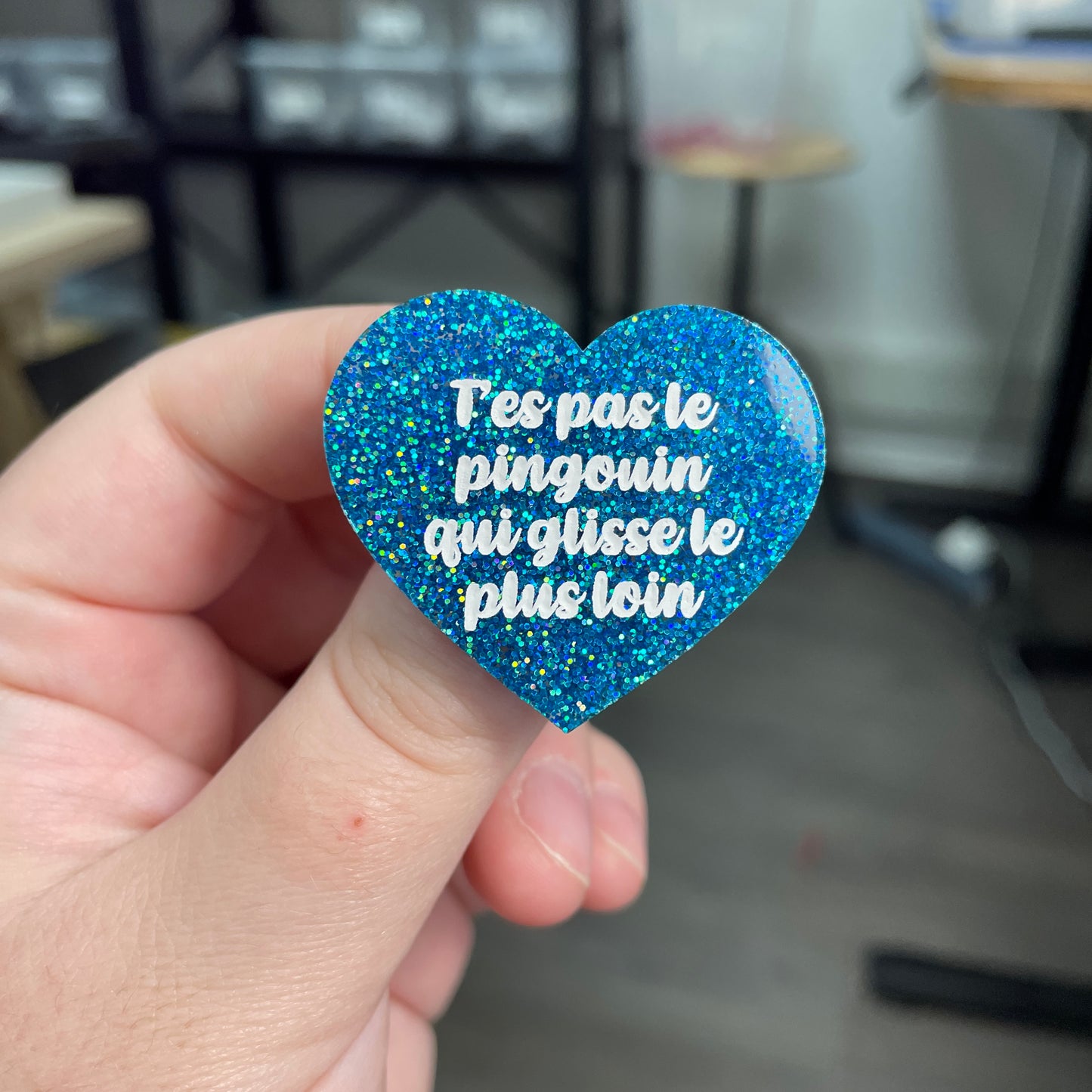 Broche "T'es pas le pingouin qui glisse le plus loin" en acrylique à paillettes bleues