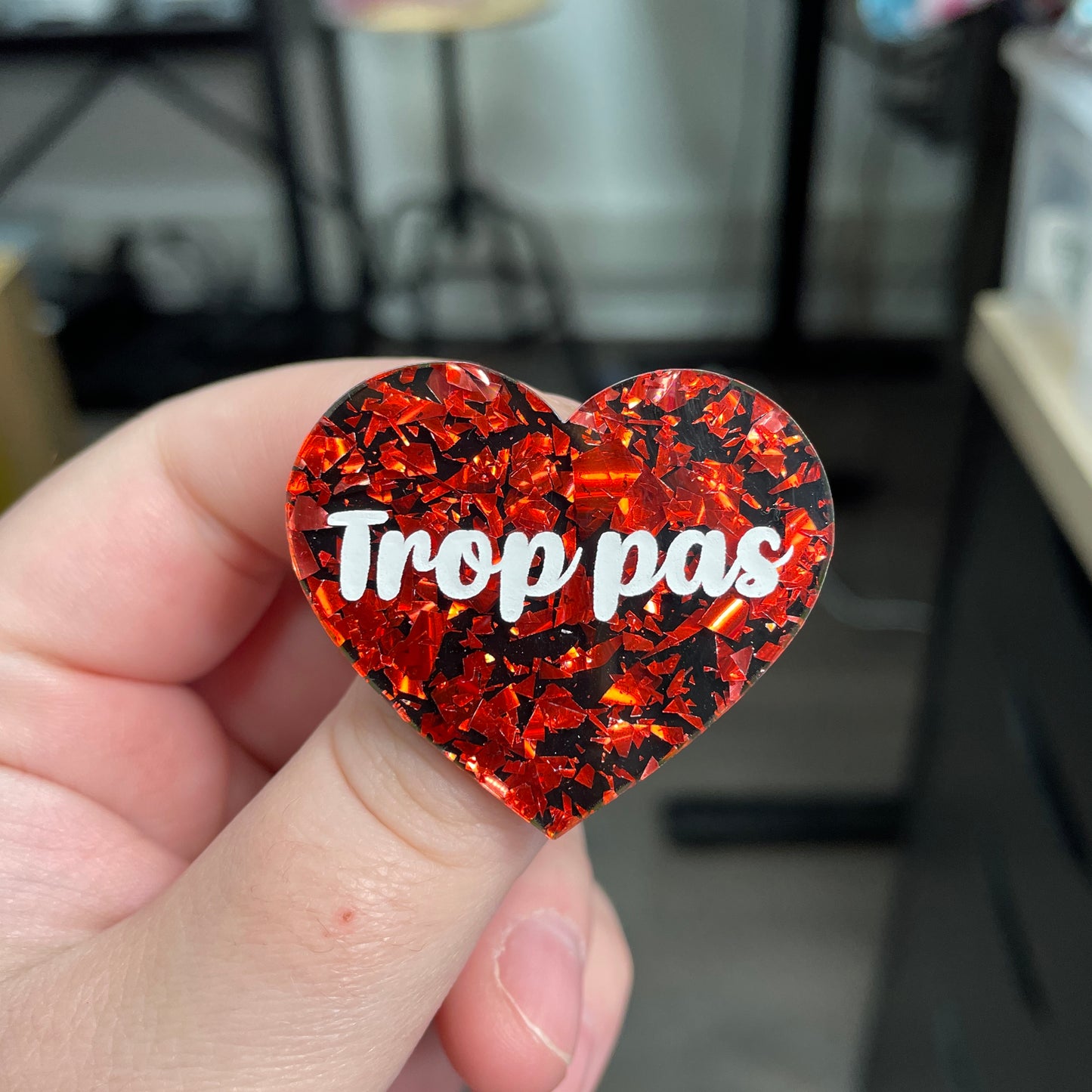 Broche "Trop pas" en acrylique noire avec des éclats de confettis rouges