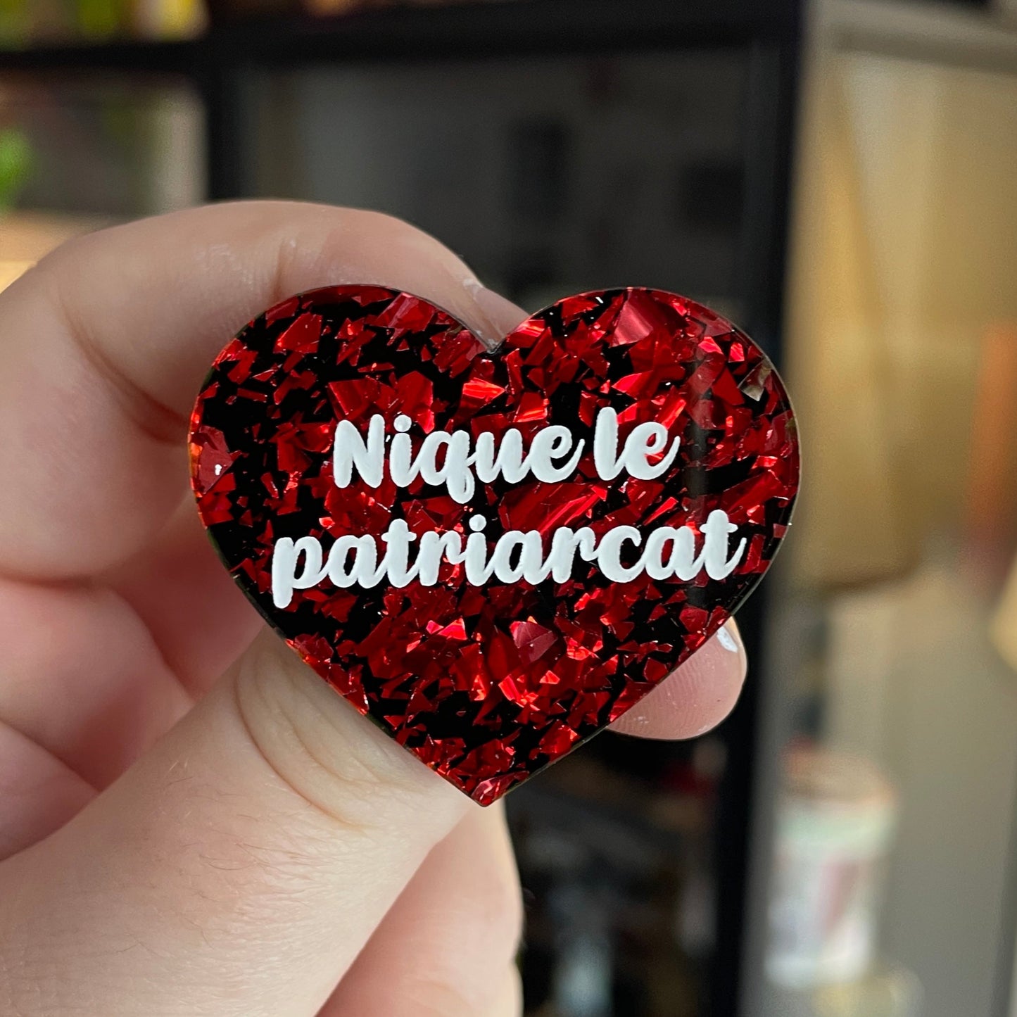 Broche "Nique le patriarcat" en acrylique noire avec des éclats de confettis rouges