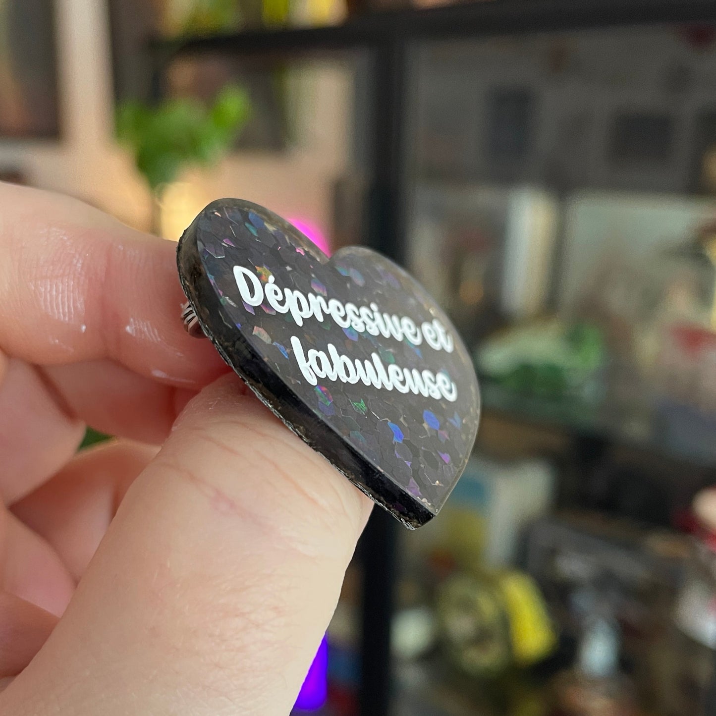 Broche "Dépressive et fabuleuse" en acrylique semi-transparente avec des confettis noirs