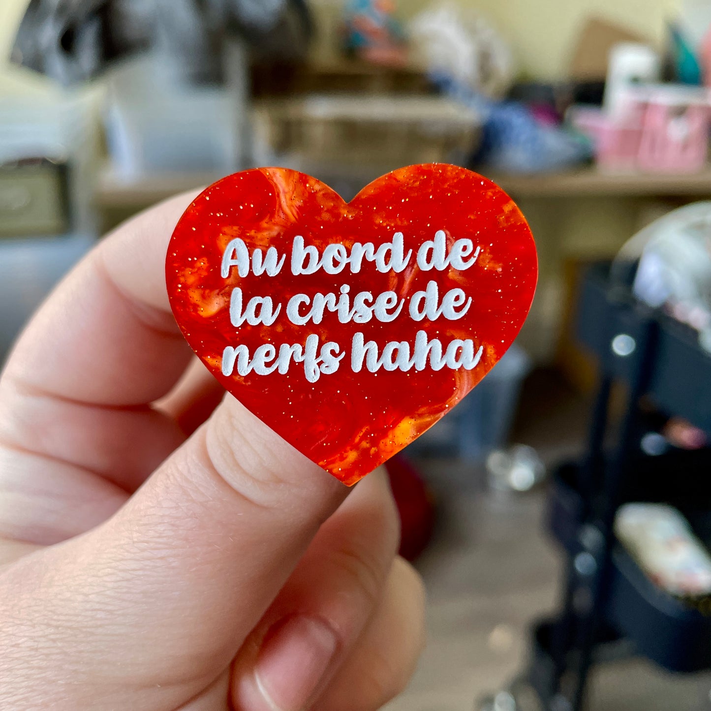 Broche "Au bord de la crise de nerfs haha" en acrylique marbrée orange à paillettes