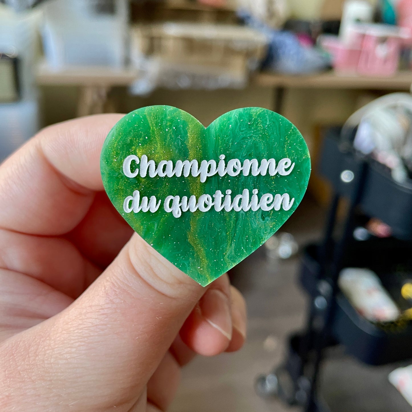 Broche "Championne du quotidien" en acrylique marbrée verte et dorée