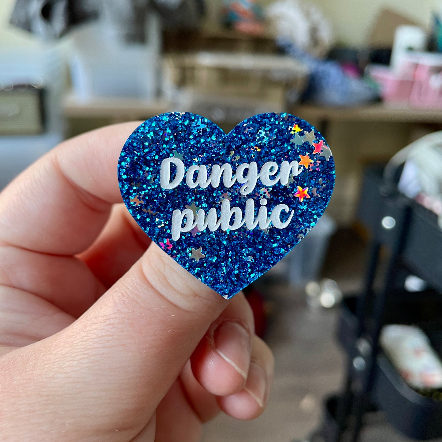 Broche "Danger public" en acrylique à paillettes bleues avec des confettis étoiles