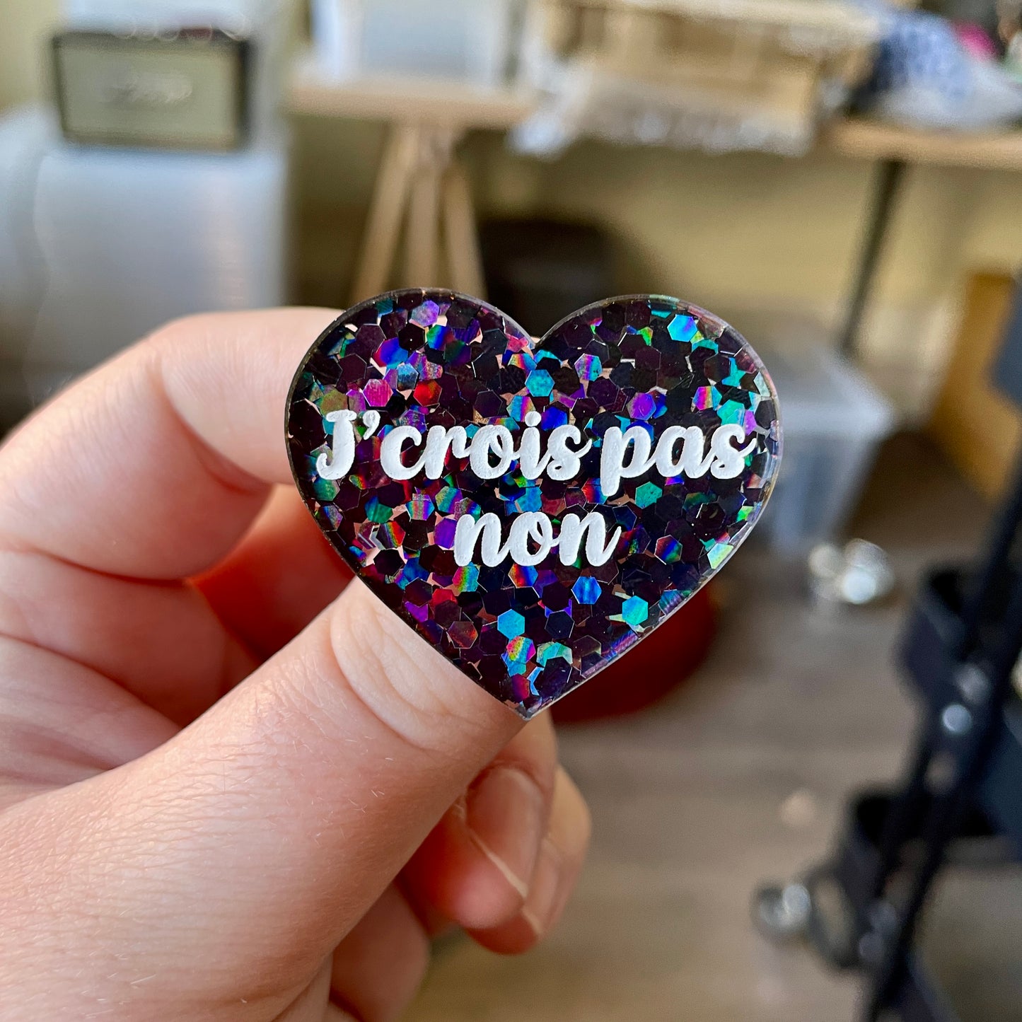 Broche "J'crois pas non" en acrylique semi-transparente avec des confettis noirs