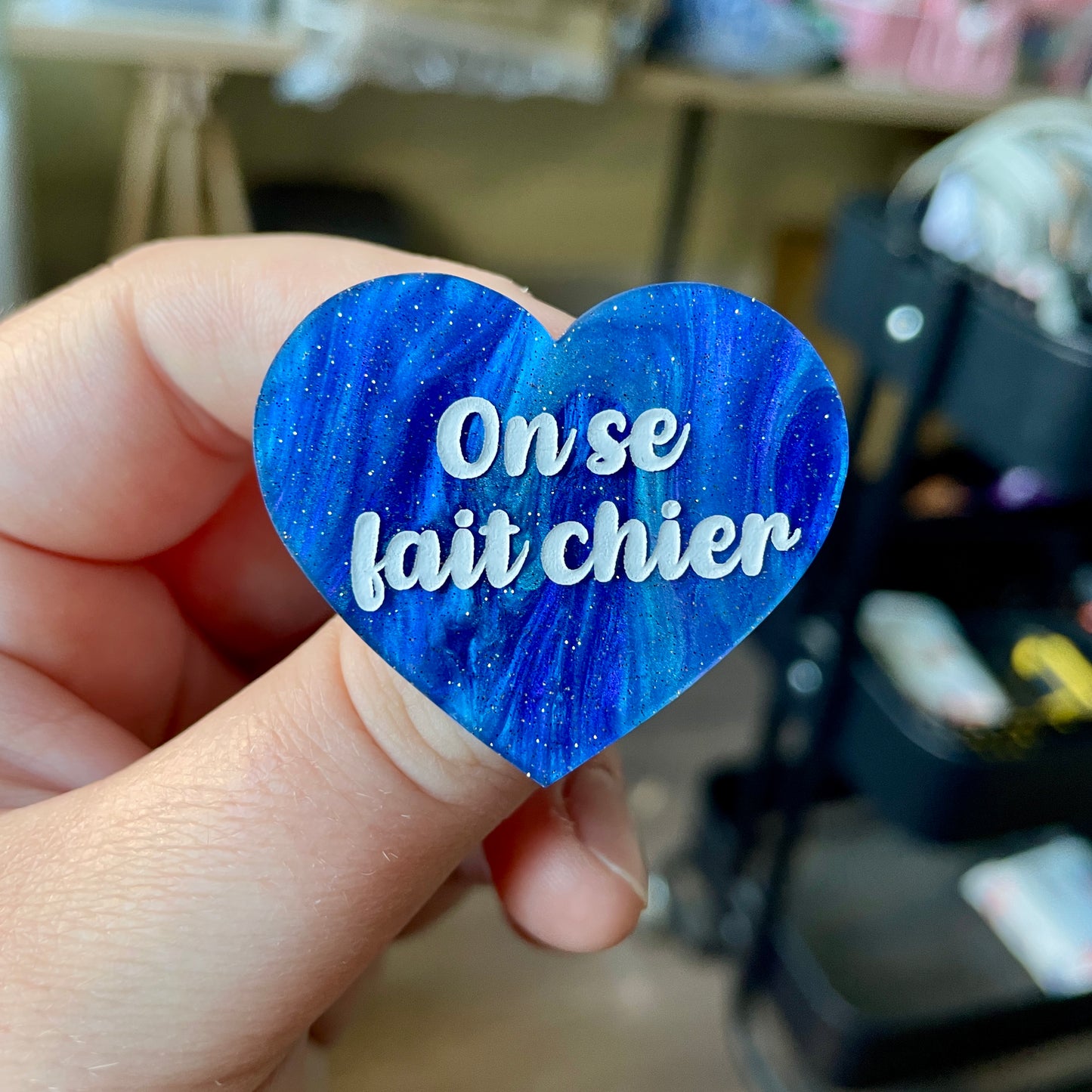 Broche "On se fait chier" en acrylique marbrée bleue à paillettes