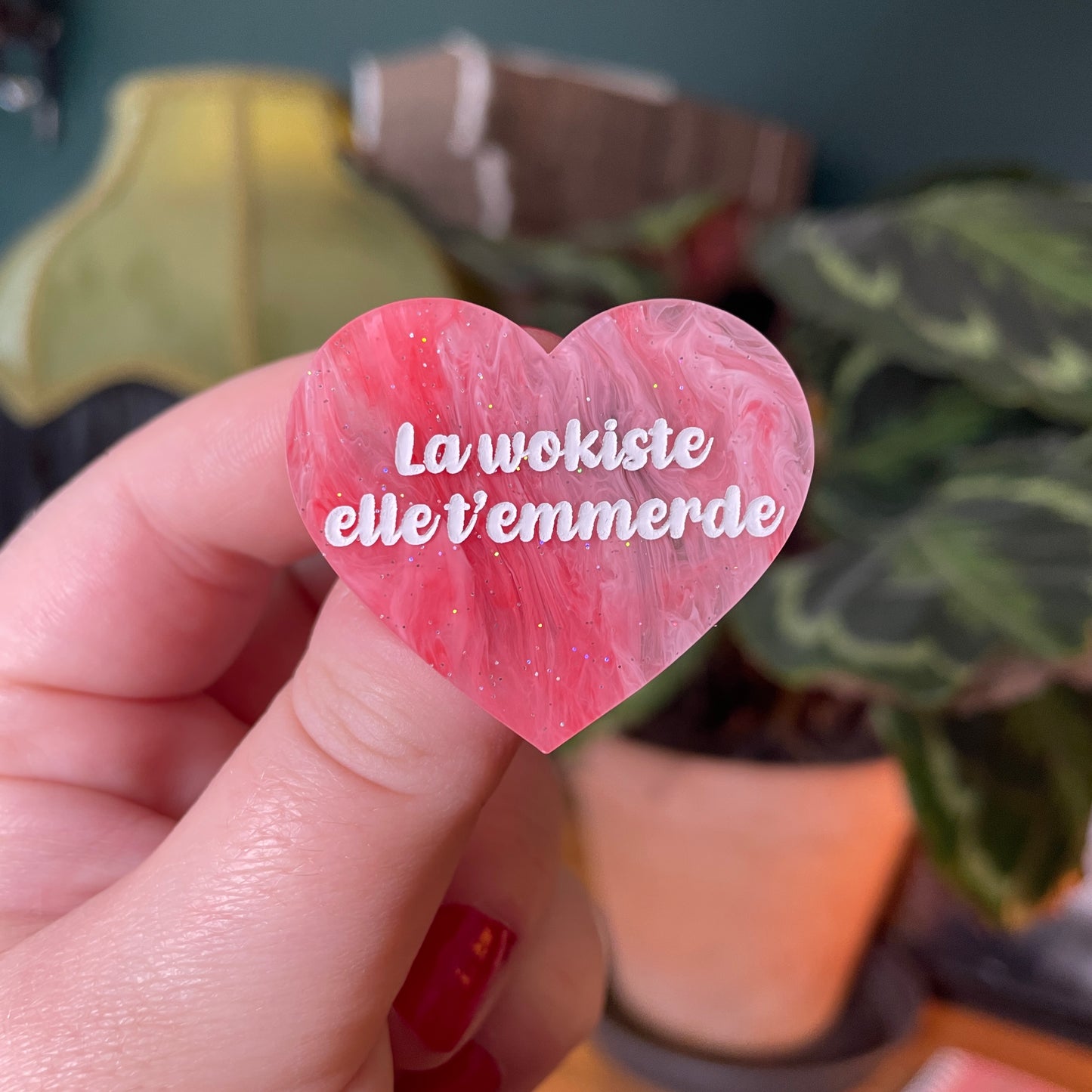 Broche "La wokiste elle t'emmerde" en acrylique marbrée rouge et rose à paillettes