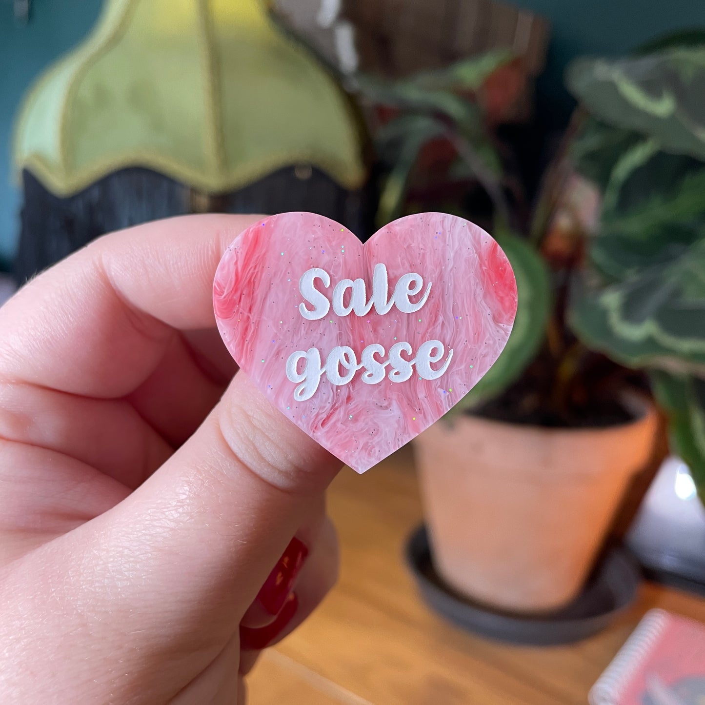 Broche "Sale gosse" en acrylique marbrée rouge et rose à paillettes