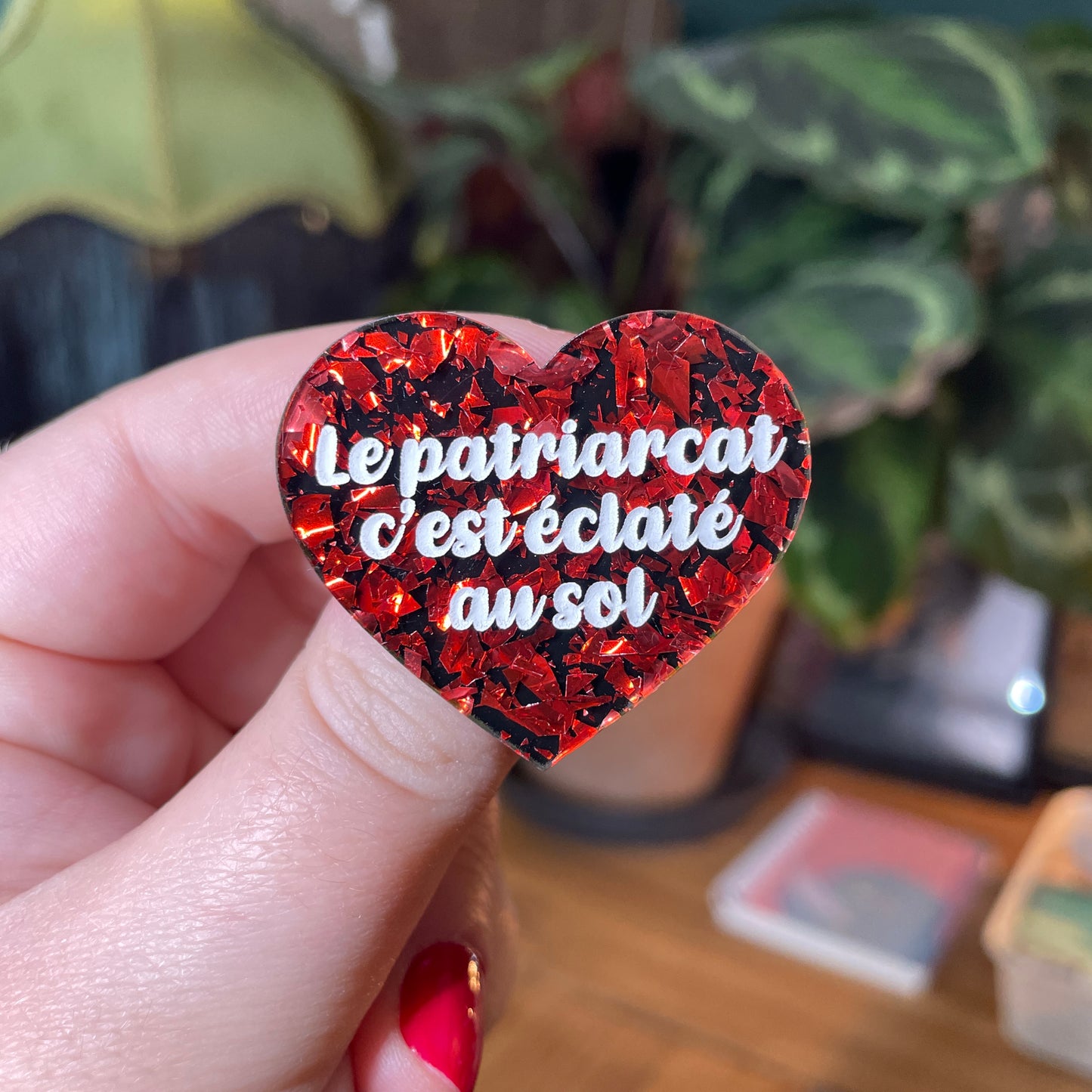 Broche "Le patriarcat c'est éclaté au sol" en acrylique noire avec des éclats de confettis rouges