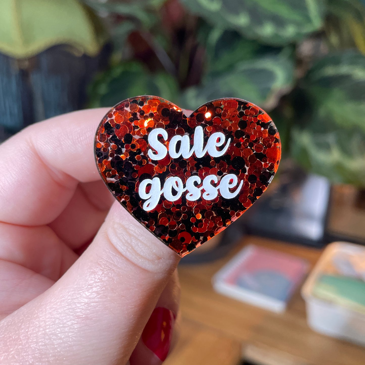 Broche "Sale gosse" en acrylique semi transparente avec des pois rouges et noirs