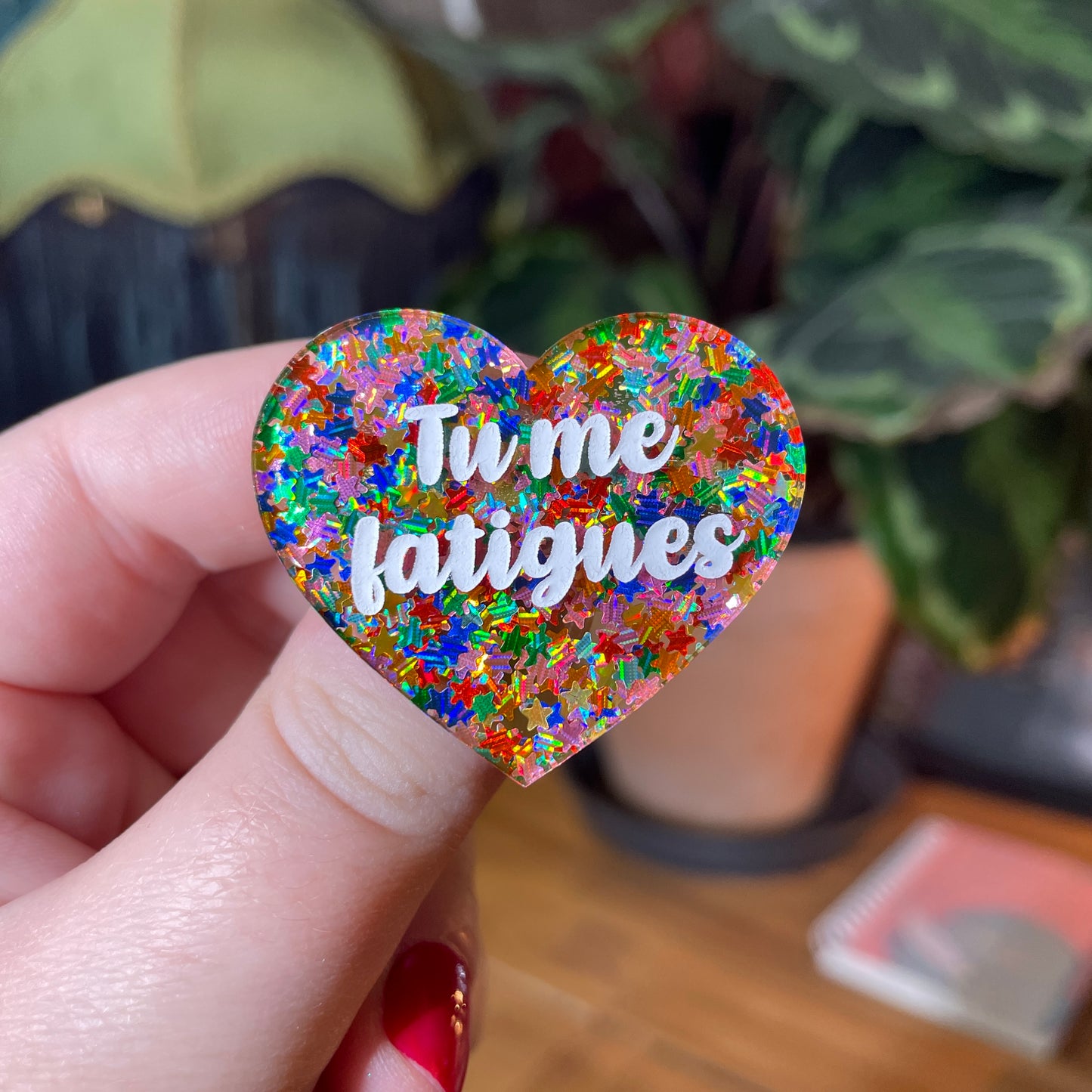 Broche "Tu me fatigues" en acrylique semi transparente avec des étoiles multicolores