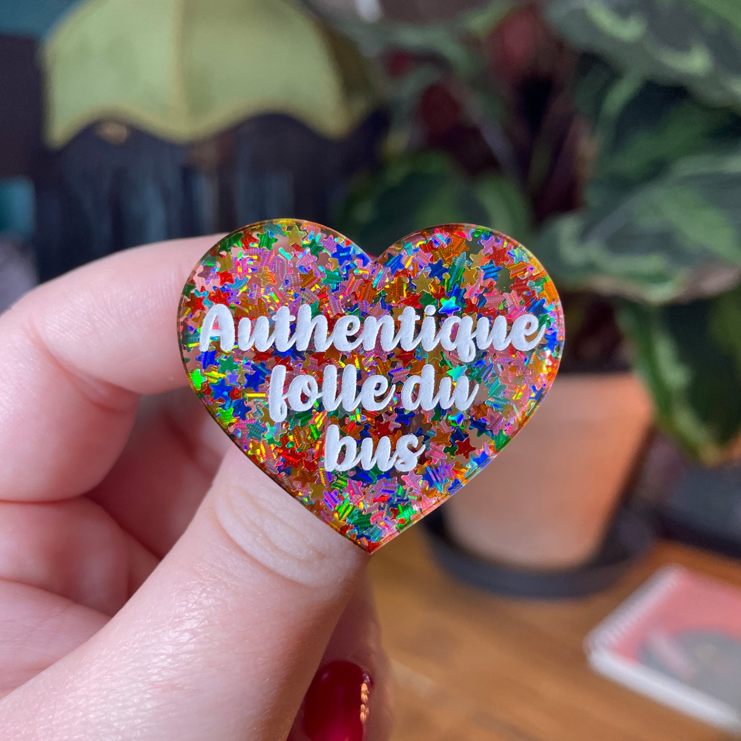 Broche "Authentique folle du bus" en acrylique semi transparente avec des étoiles multicolores