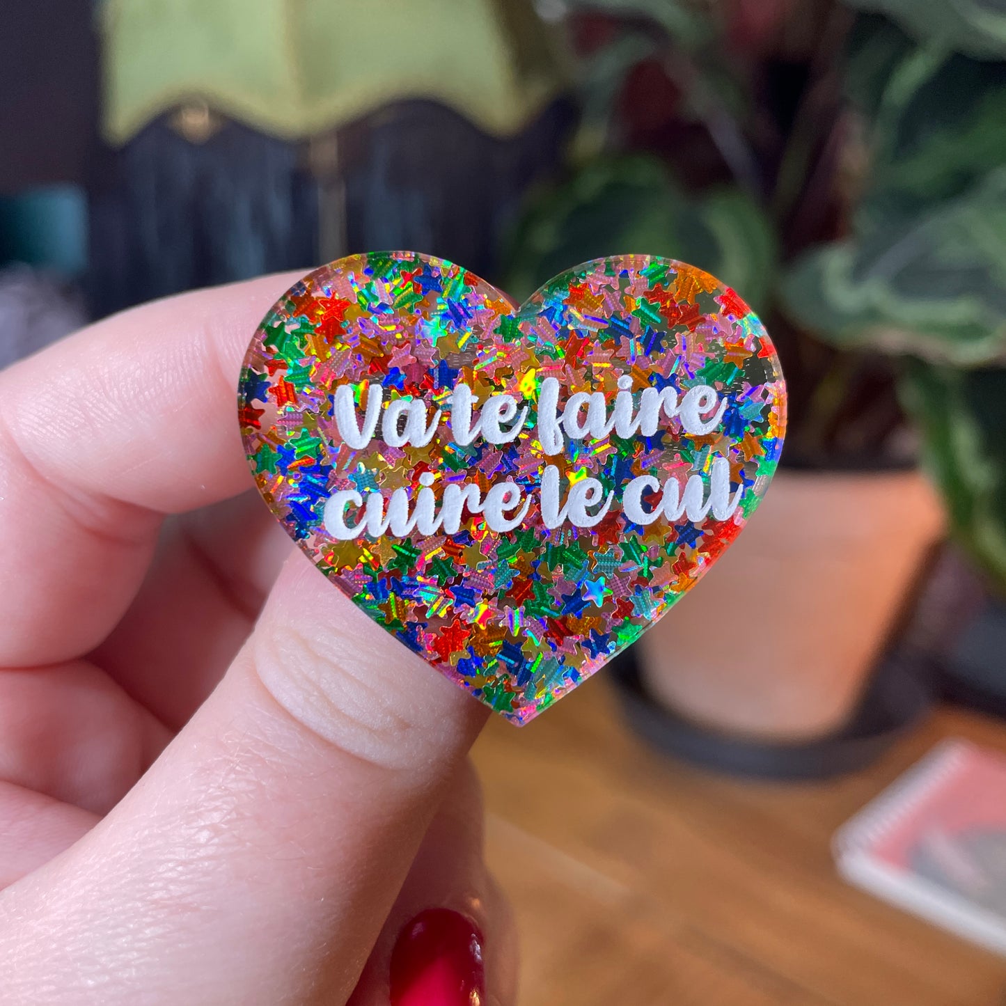 Broche "Va te faire cuire le cul" en acrylique semi transparente avec des étoiles multicolores
