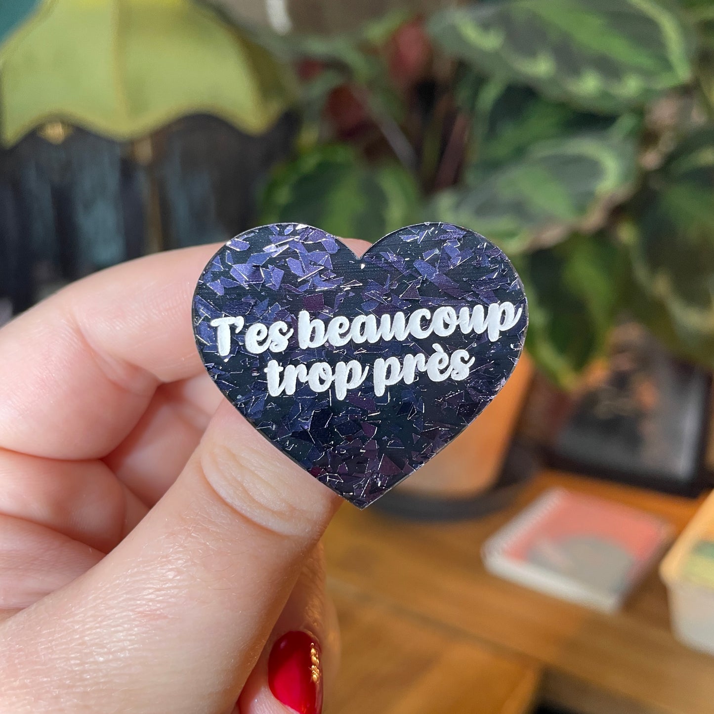 Broche "T'es beaucoup trop près" en acrylique noire avec des éclats de confettis gris