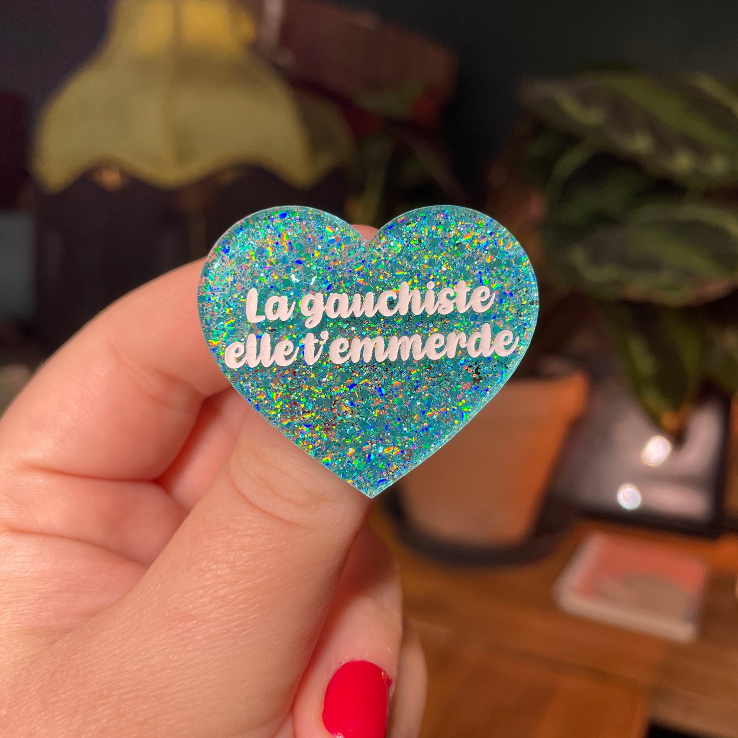 Broche "La gauchiste elle t'emmerde" en acrylique semi transparente avec des paillettes turquoise
