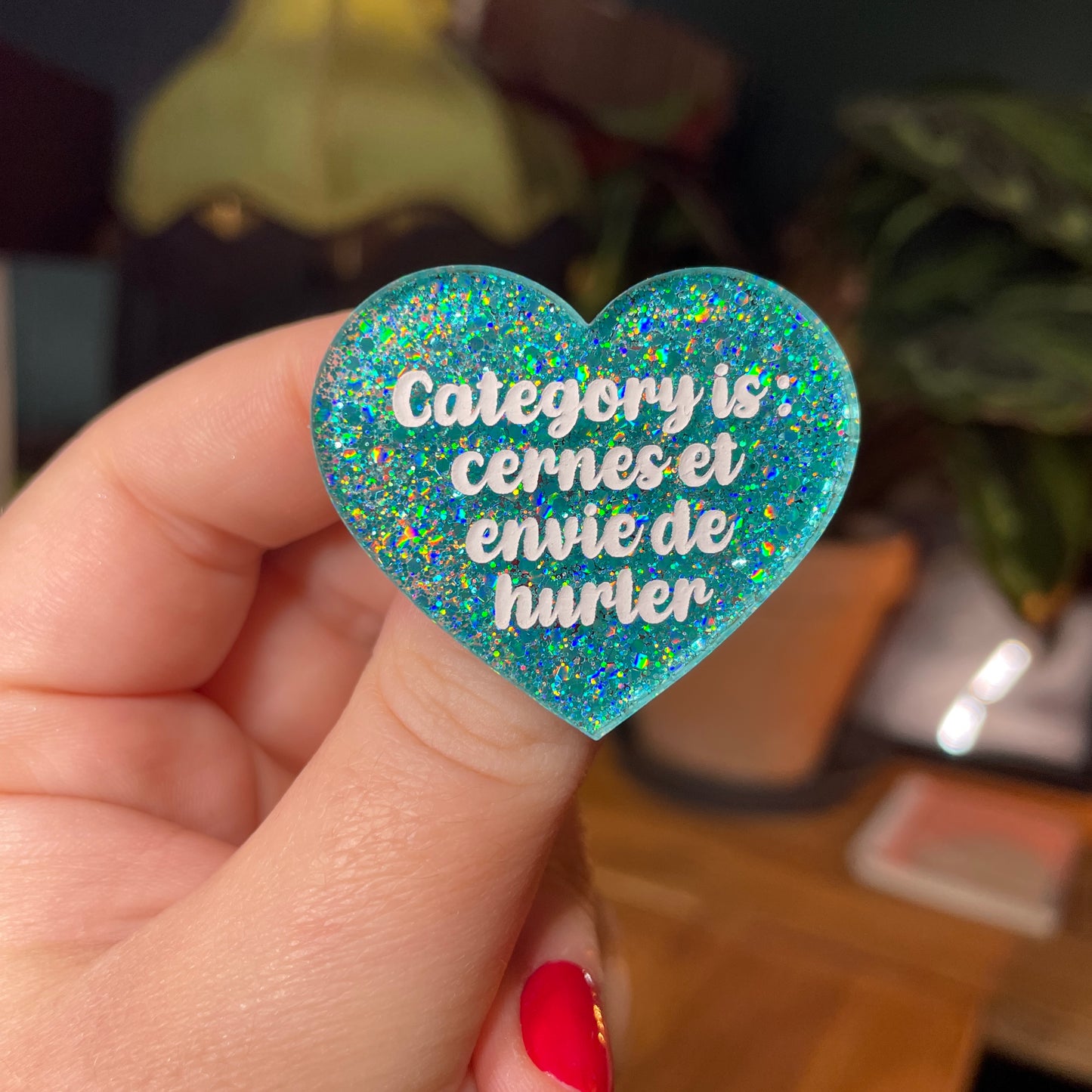Broche "Category is : cernes et envie de hurler" en acrylique semi transparente avec des paillettes turquoise