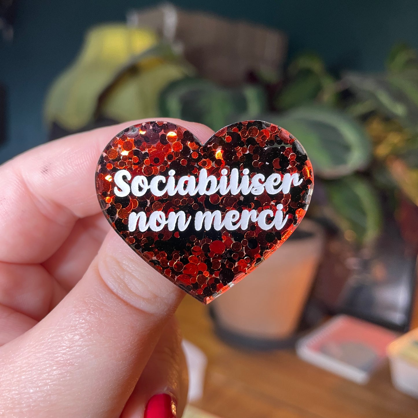 Broche "Sociabiliser non merci" en acrylique semi transparente avec des pois rouges et noirs
