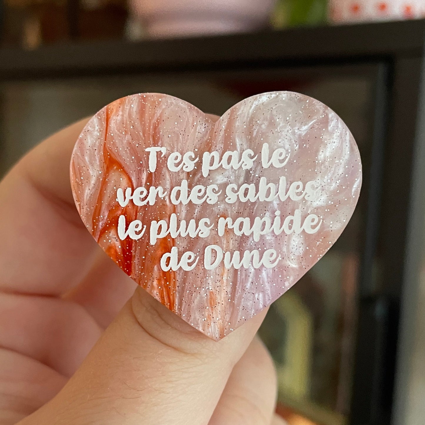 Broche "T'es pas le ver des sables le plus rapide de Dune" en acrylique marbrée blanche et orange à paillettes