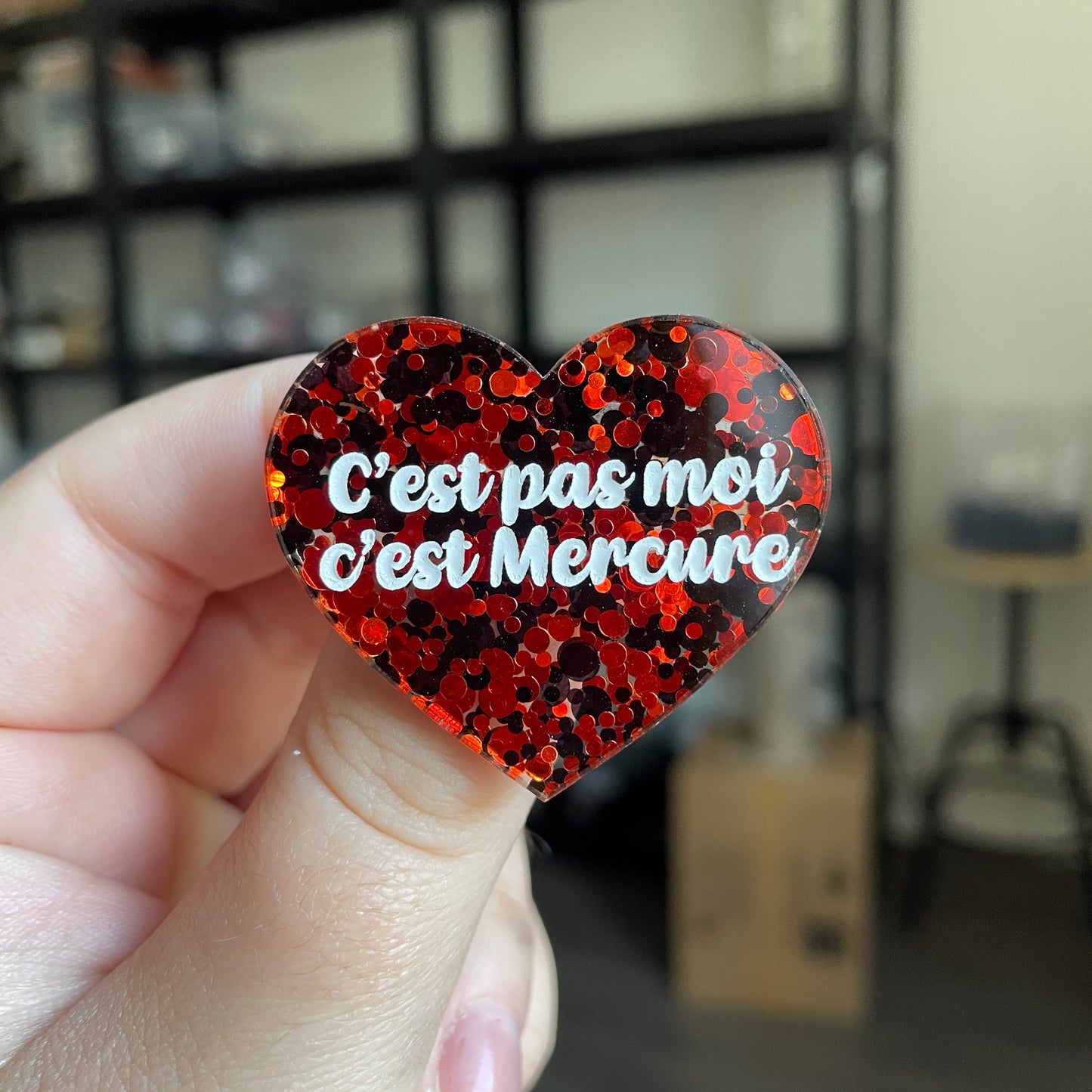 Broche "C'est pas moi c'est Mercure" en acrylique semi transparente avec des pois rouges et noirs