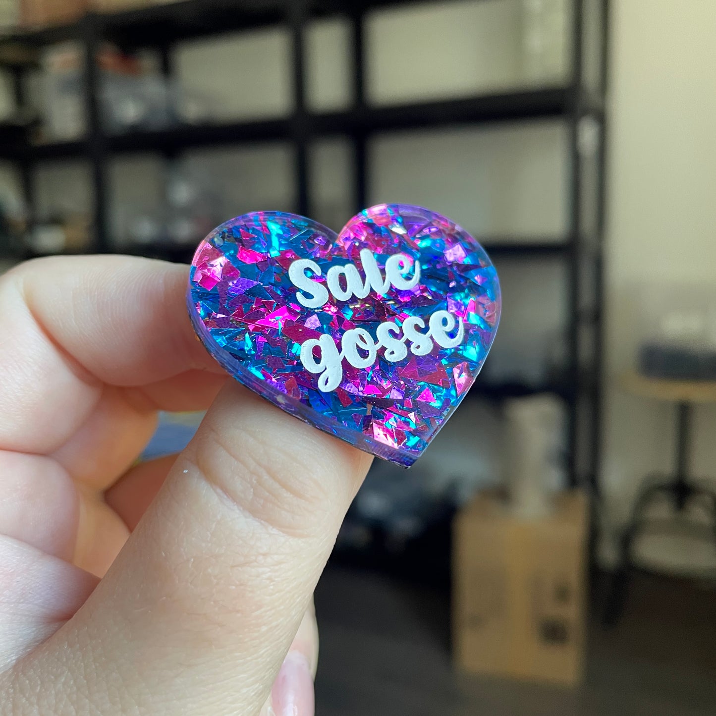 Broche "Sale gosse" en acrylique transparente avec des éclats de confettis bleus et violets/roses