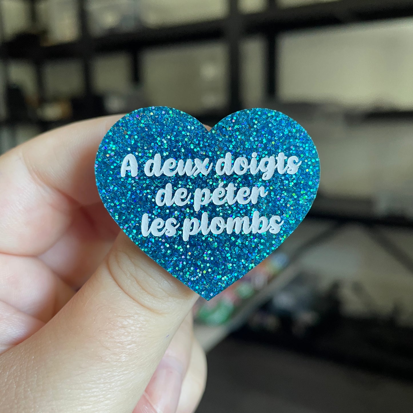Broche "A deux doigts de péter les plombs" en acrylique à paillettes bleues
