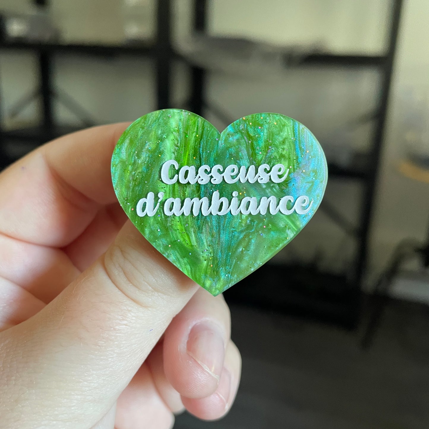 Broche "Casseuse d'ambiance" en acrylique marbrée verte à paillettes