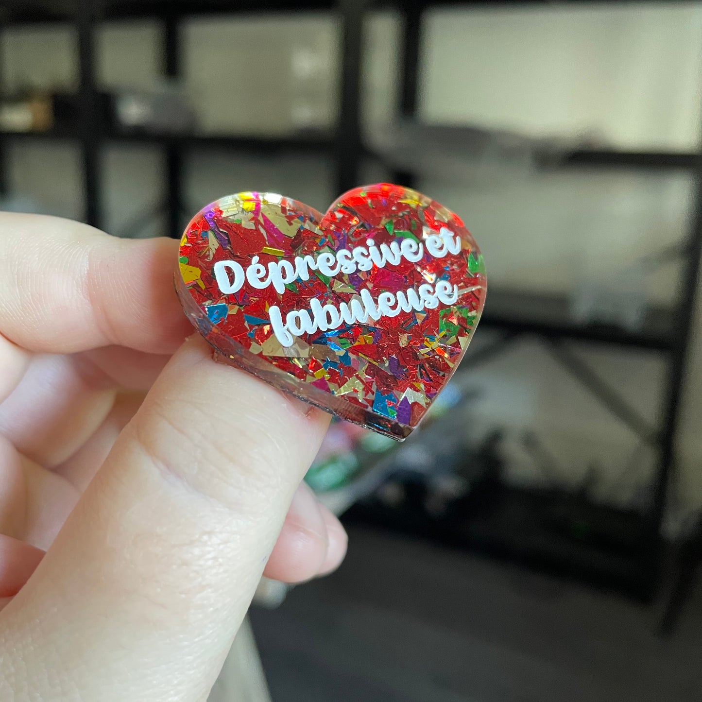 Broche "Dépressive et fabuleuse" en acrylique transparente avec des éclats de confettis rouges et multicolores