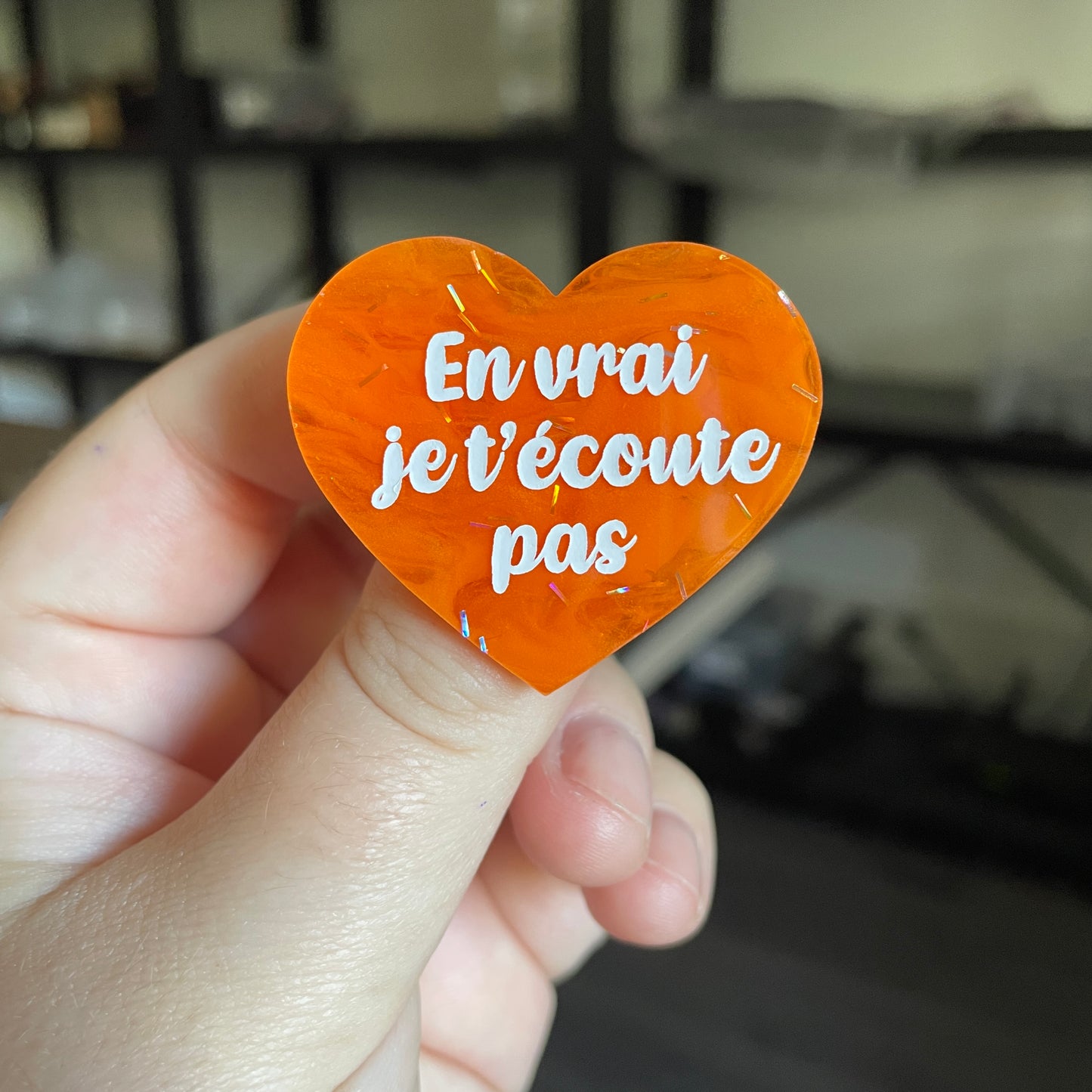 Broche "En vrai je t'écoute pas" en acrylique japonaise semi transparente orange avec des confettis