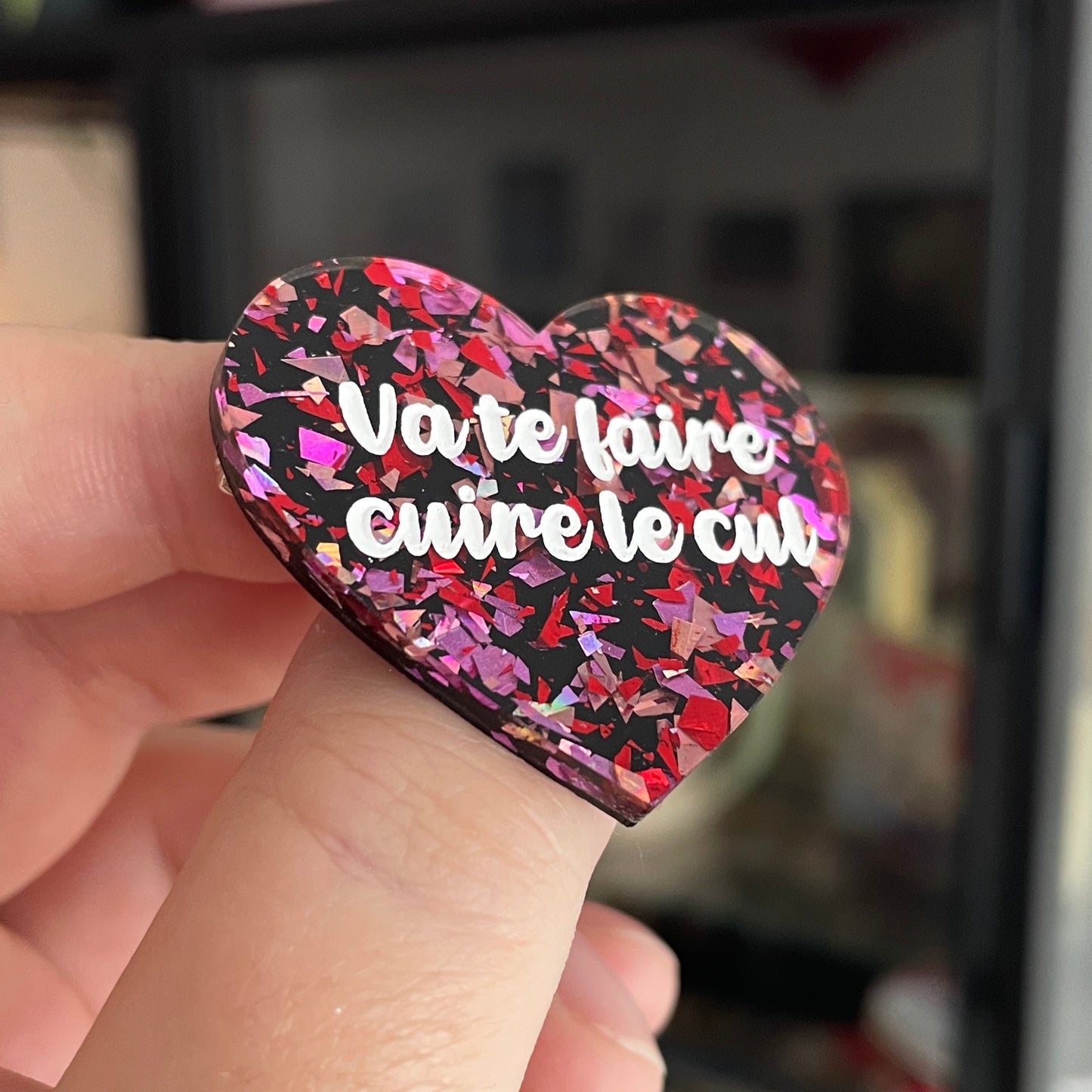 Broche "Va te faire cuire le cul" en acrylique noire avec des confettis rouges et roses