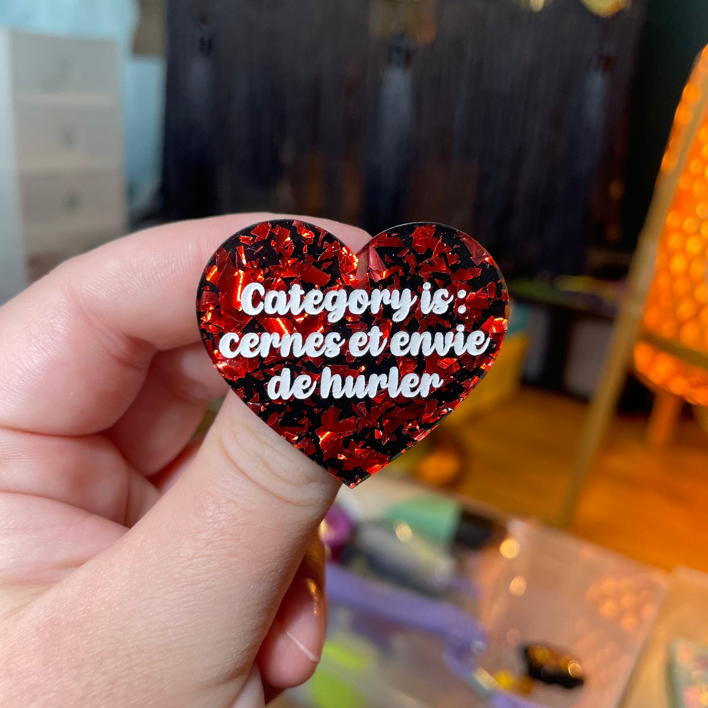 Broche "Category is : cernes et envie de hurler" en acrylique noire avec des éclats de confettis rouges