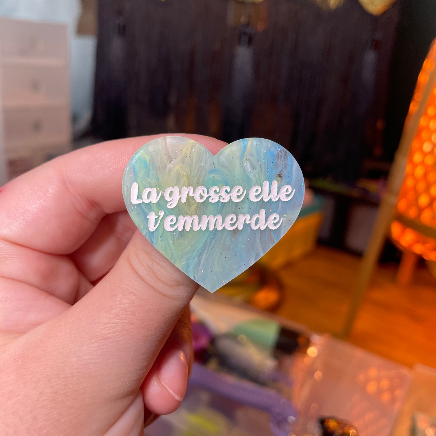 Broche "La grosse elle t'emmerde" en acrylique semi transparente marbrée bleue, jaune et blanche à paillettes