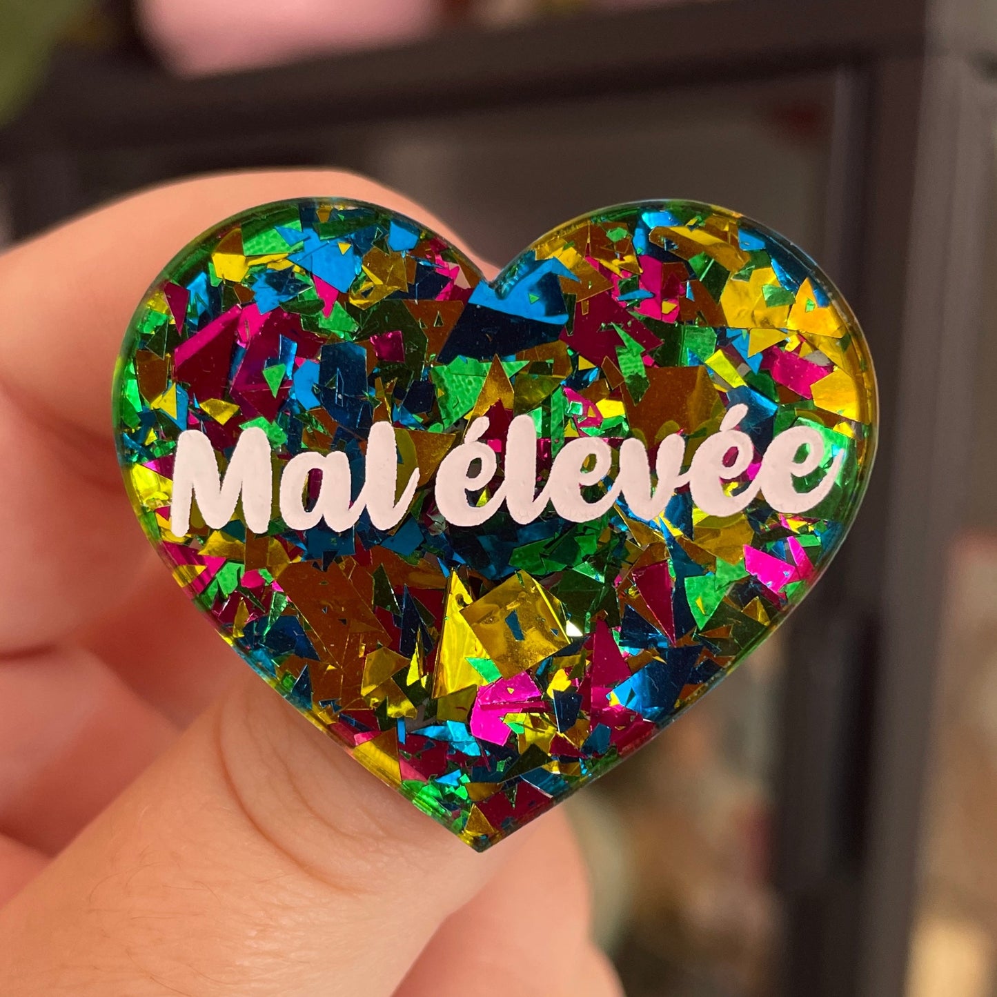 Broche "Mal élevée" en acrylique transparente à gros confettis verts, roses, jaunes et bleus